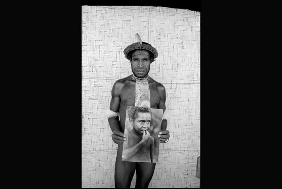 Pua in 1989, holding a picture of himself as the young swineherd featured in “Dead Birds,” filmed 28 years before. 