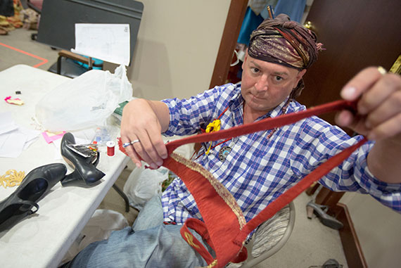 Costume designer Arthur Oliver attends to the details of the intricate costumes.