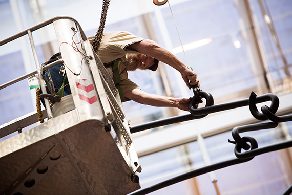 A new piece by Mexican artist Carlos Amorales is installed from the courtyard ceiling of the Harvard Art Museums. The installation is a large mobile made up of 16 large steel triangles. Jeff Cook is pictured during the installation. Photos by Stephanie Mitchell/Harvard Staff Photographer