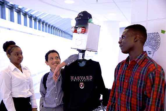 Marly Burgos (from left), Pedro Cintron, and Uchenna Eke introduce a robot named Bob Jr.