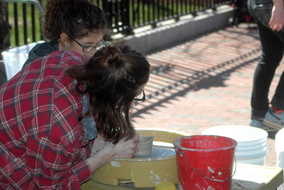 An artist teaches a young girl how to use a potter’s wheel as part of the hands-on segments of the festival. Photo by Erin Tucker