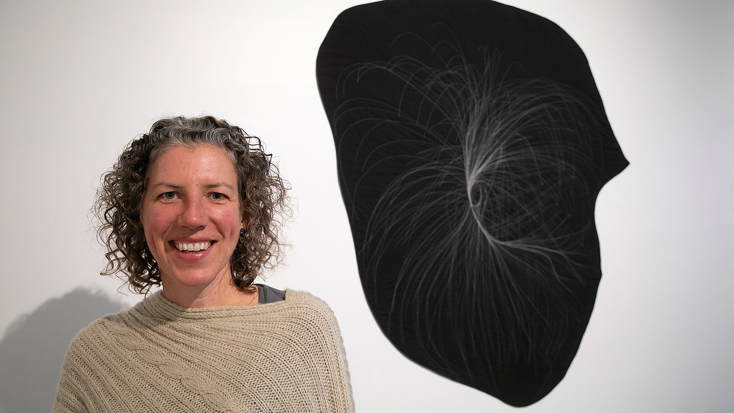 Artist Anna von Mertens with one of her quilts mapping stars.