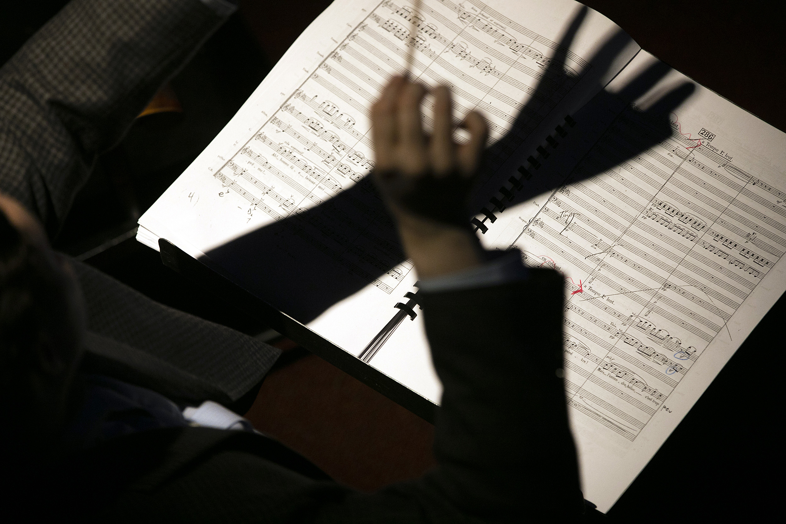 arms conducting in front of sheet music