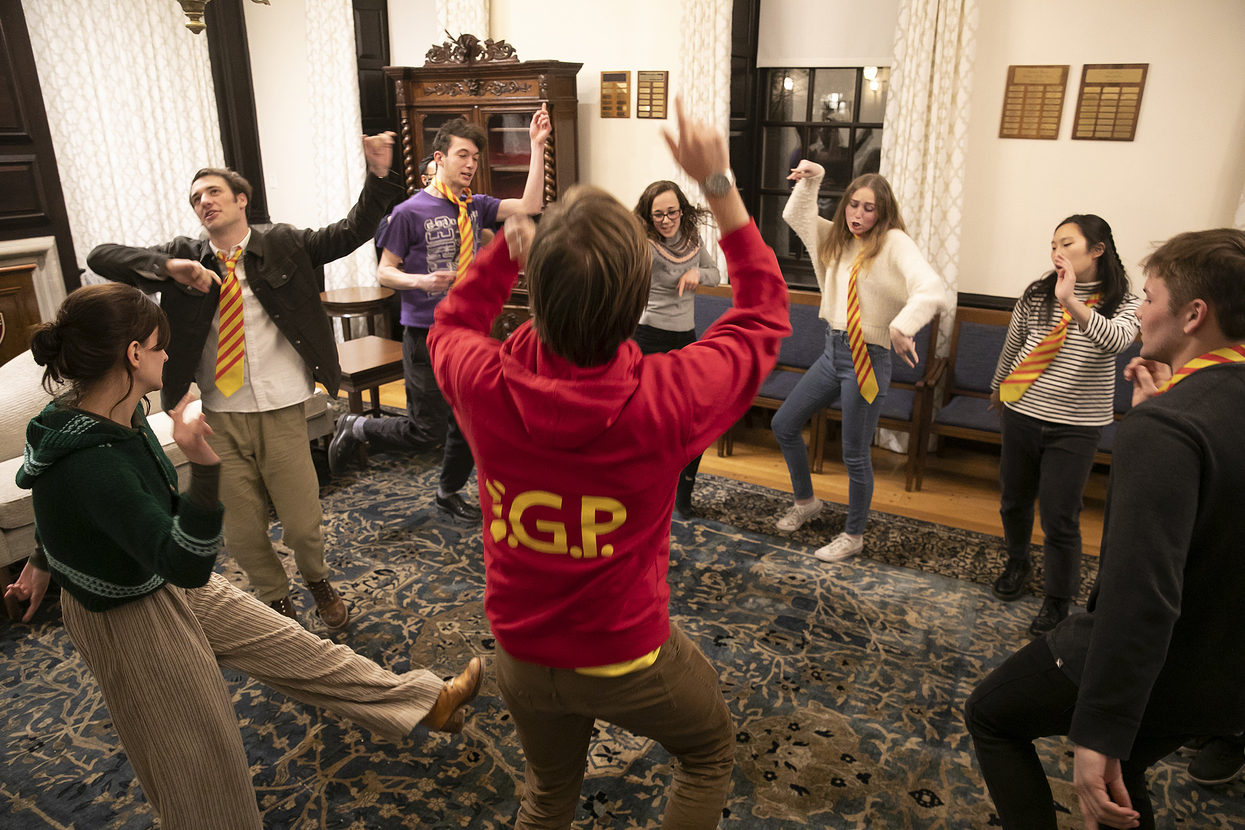 Students in a circle strike poses to practice their improv techniques.