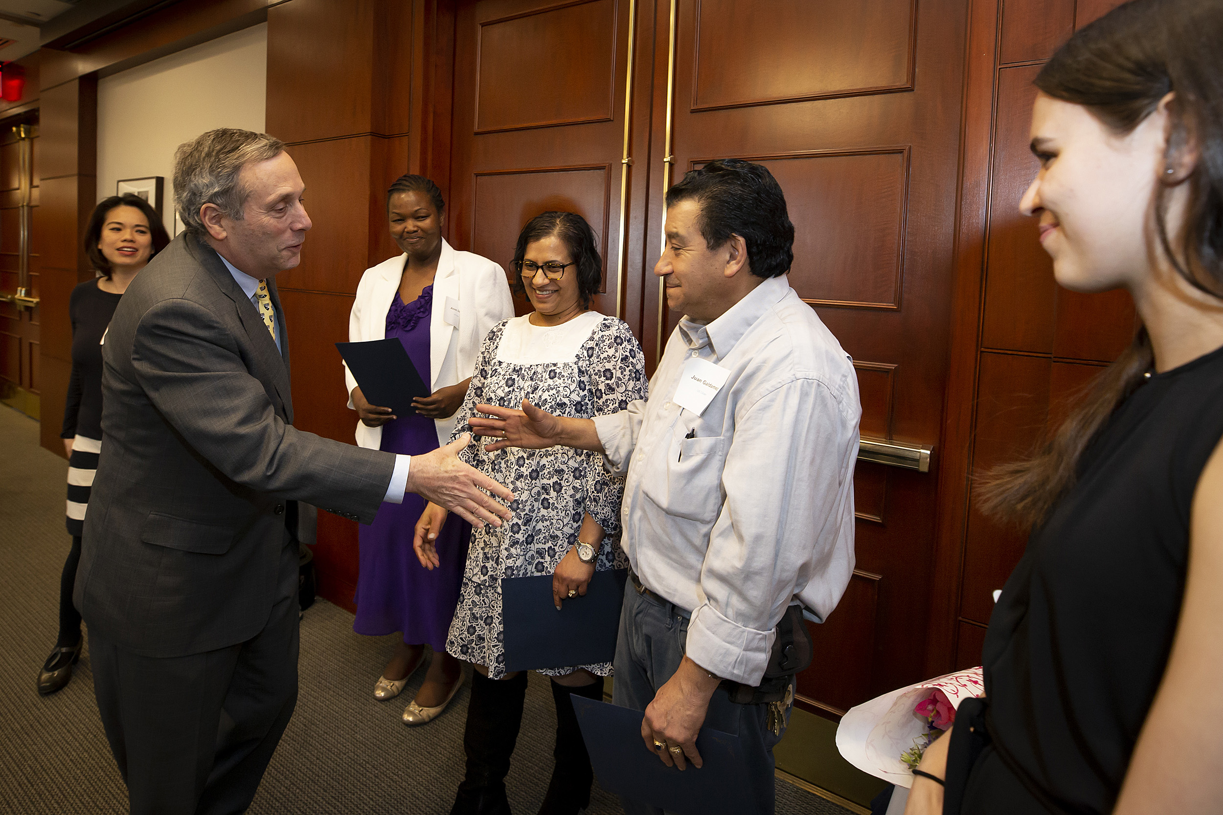 Harvard University President Bacow, congratulates new citizens at the Bridge Program annual dinner.