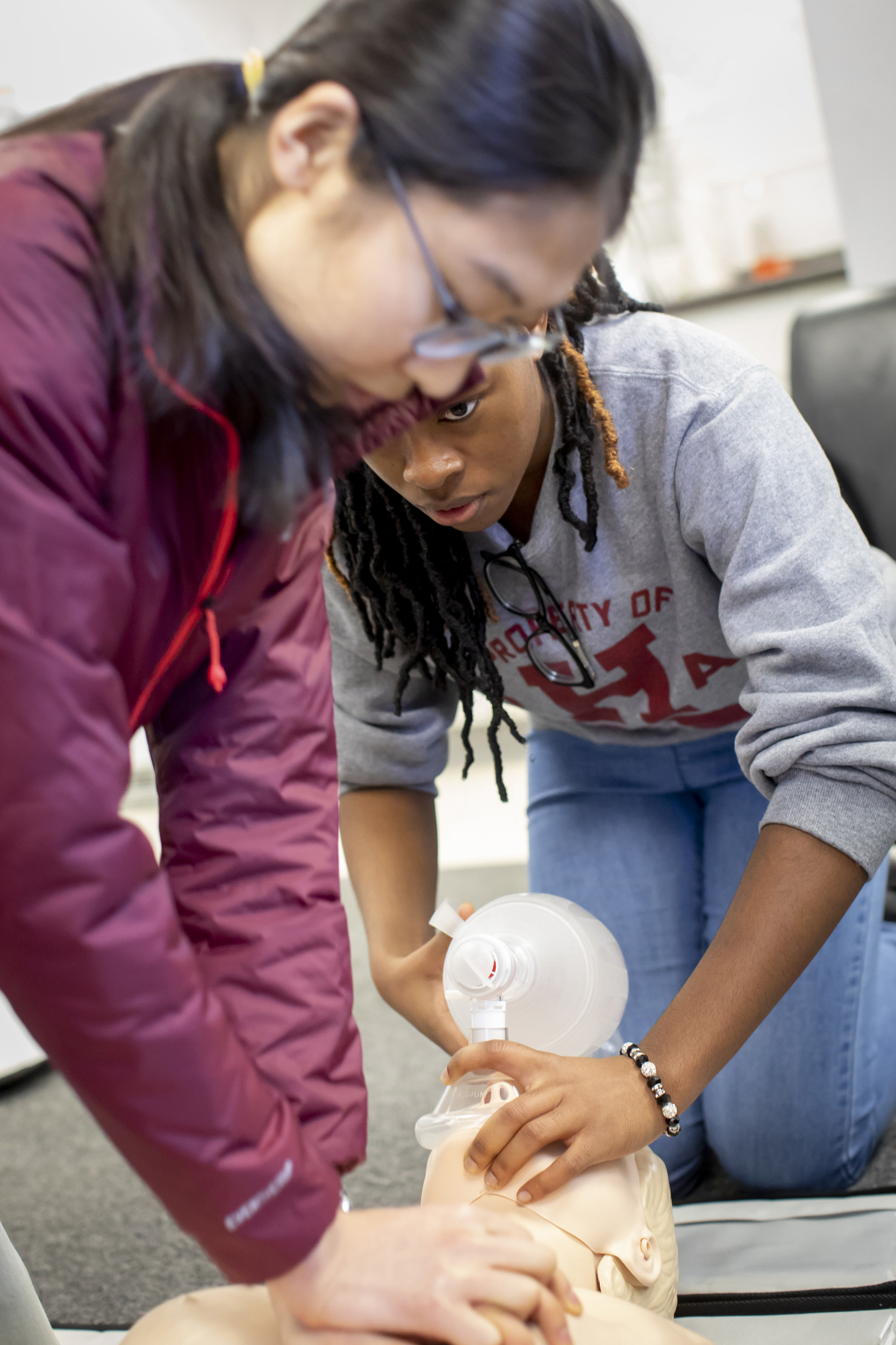 Students perform CPR on a dummy.