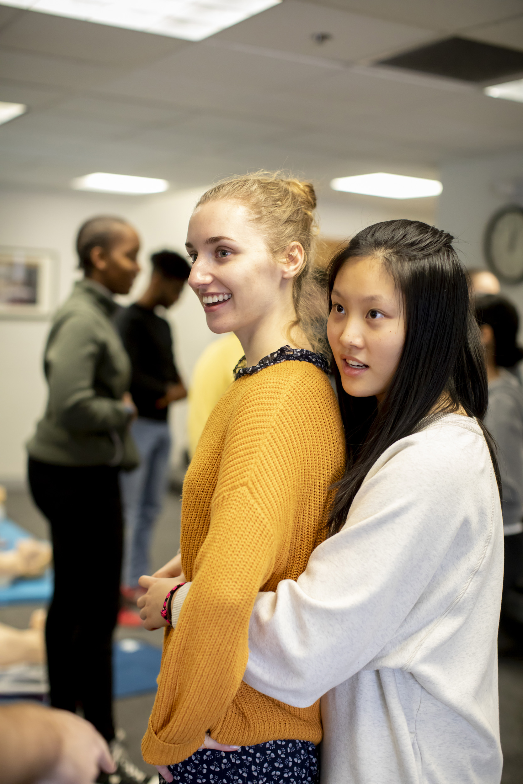 A student performs the Heimlich maneuver on another.