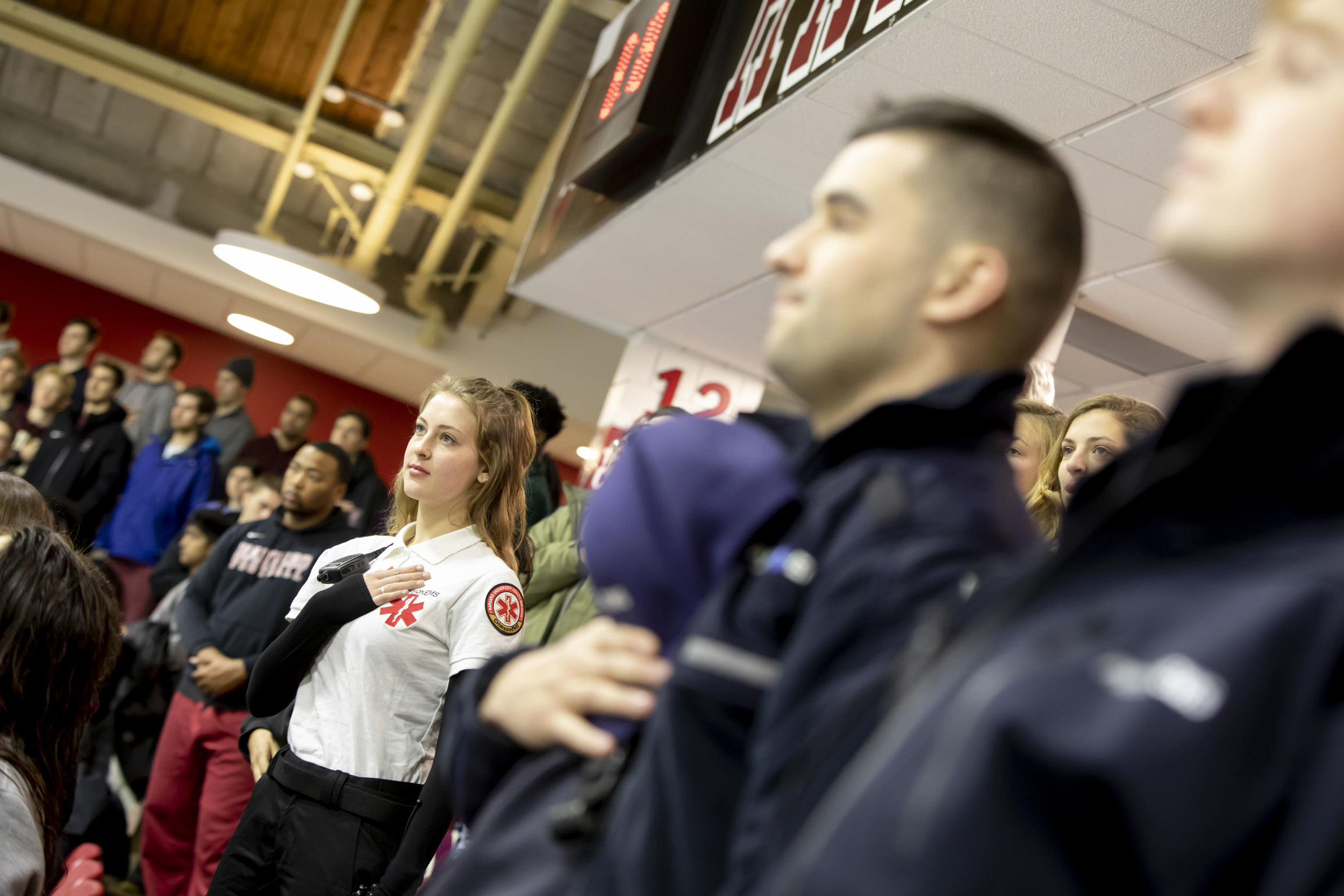 EMTs stand for the national anthem at Harvard’s Bright Arena.