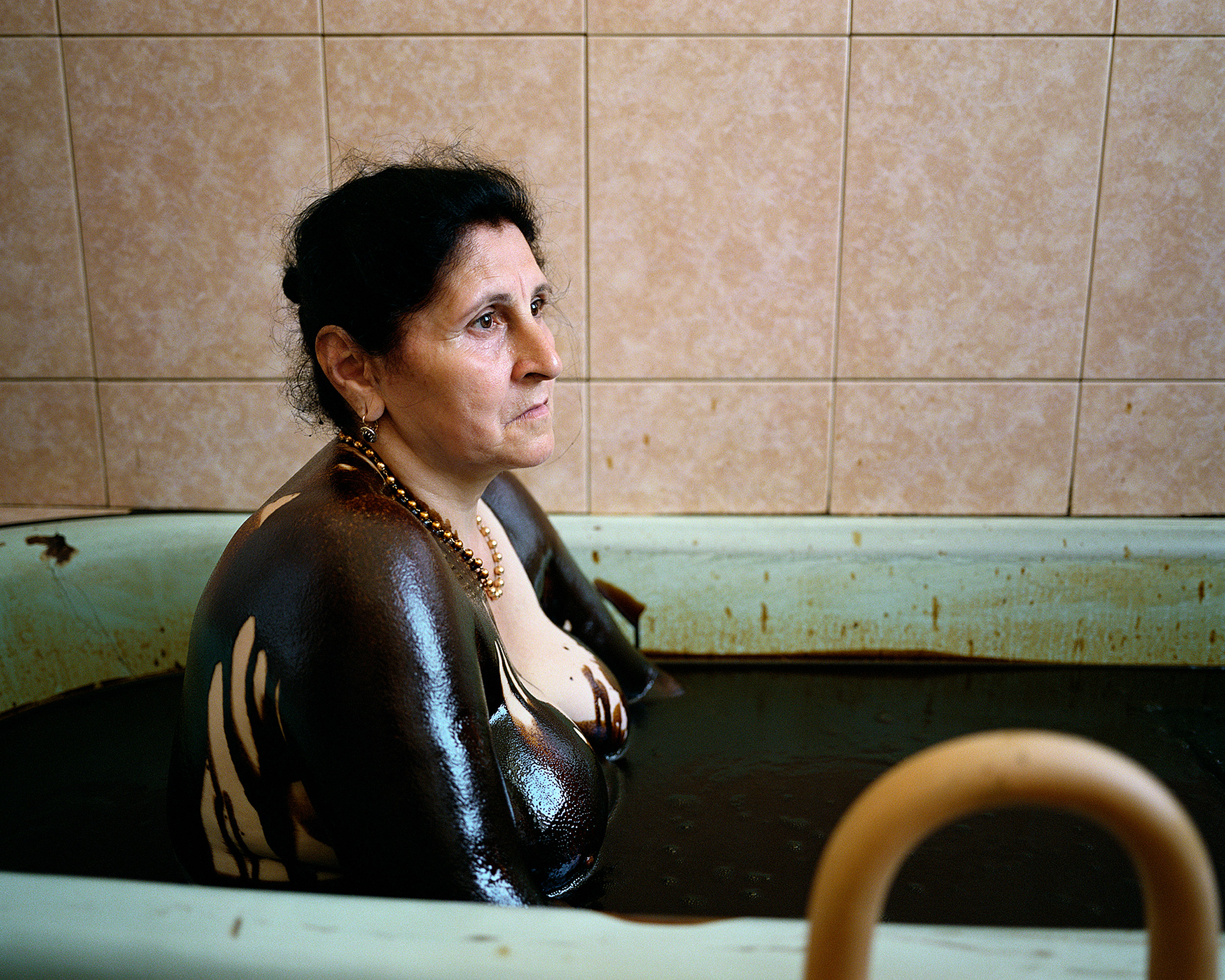 A woman bathes in crude oil, a practice said to carry medicinal benefits.