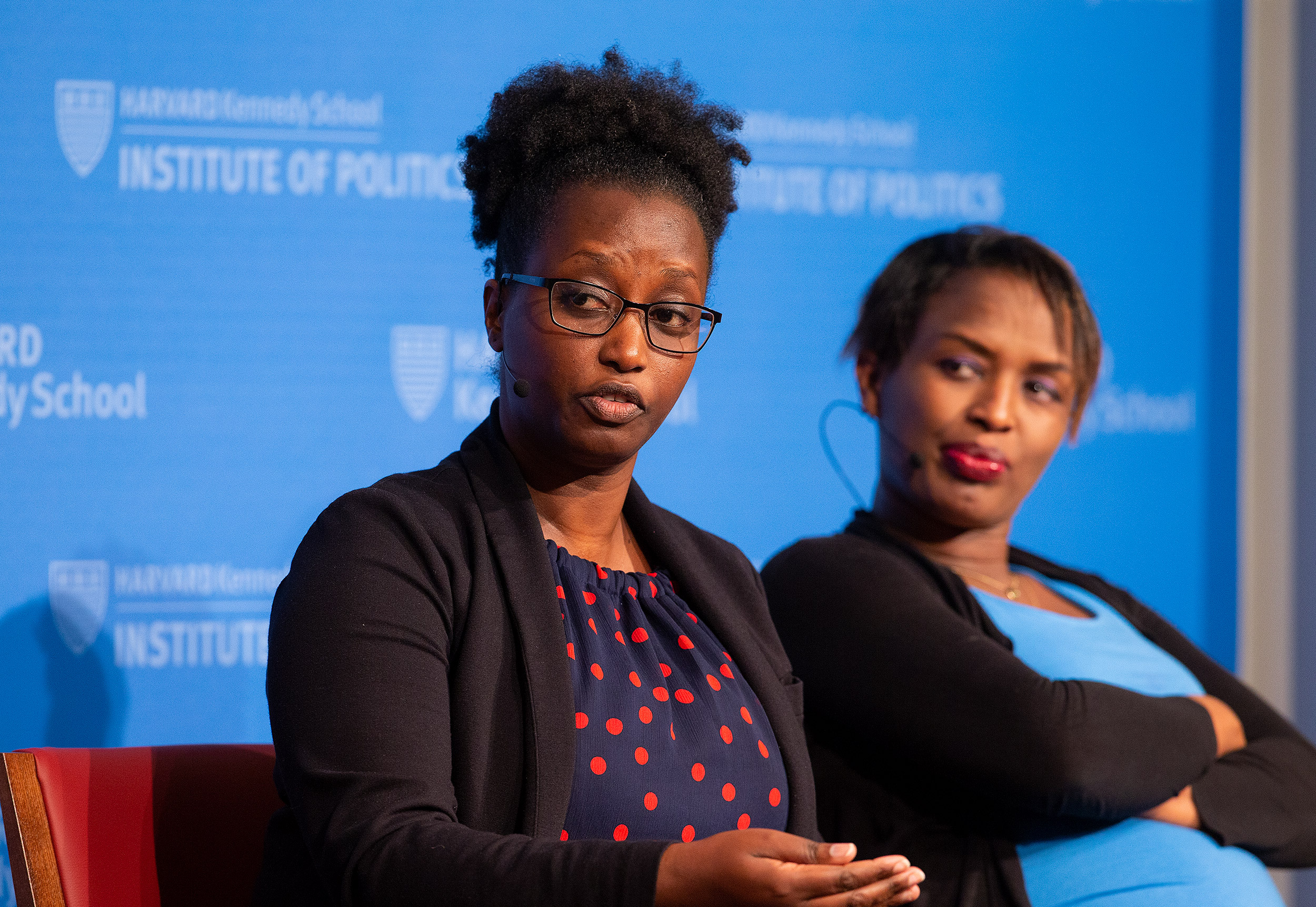 woman in foreground speaking, woman in background listening