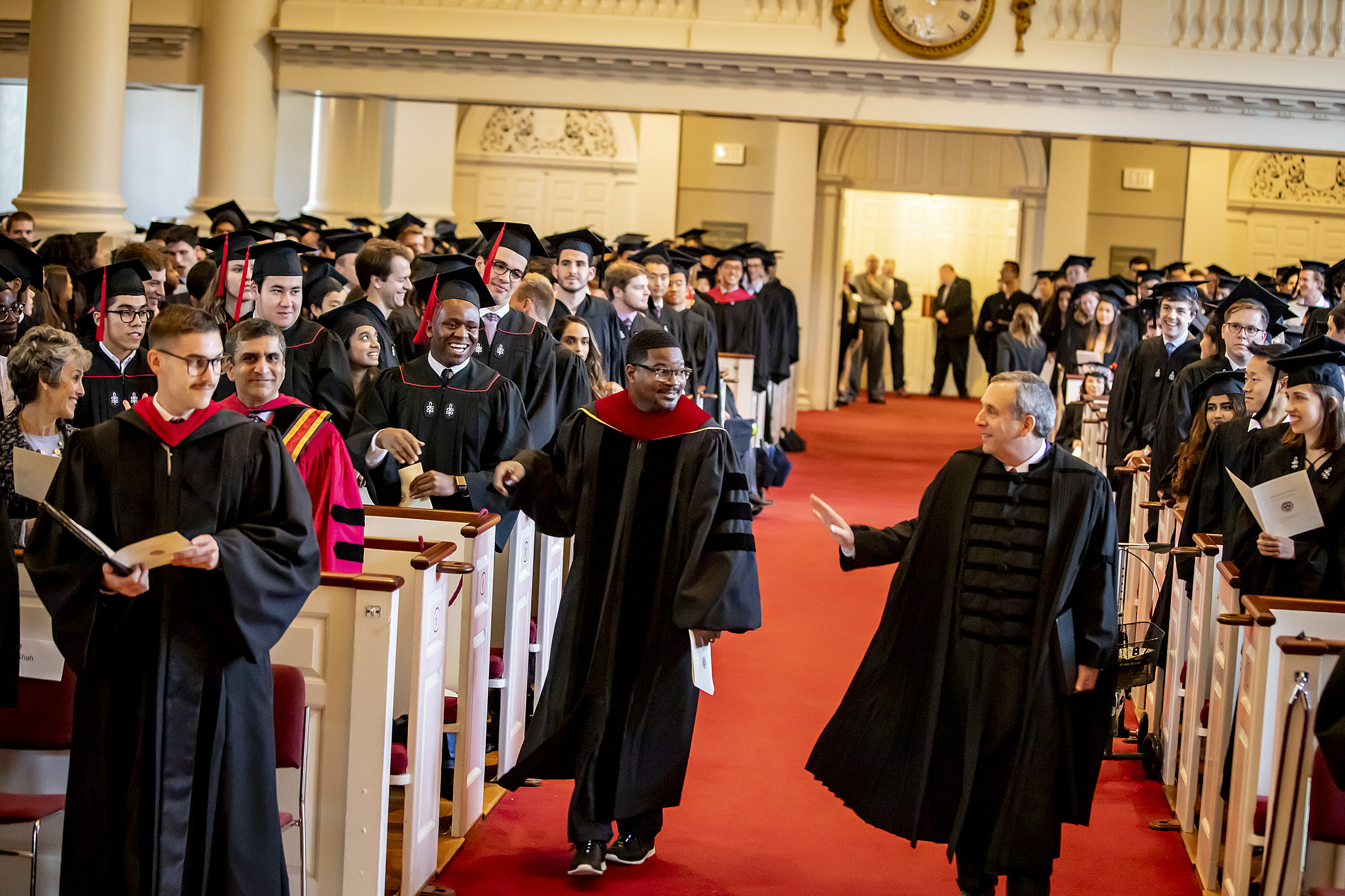 Larry Bacow and Jonathan Walton walk down the aisle of Memorial Church for the 2019 Baccalaureate Service.