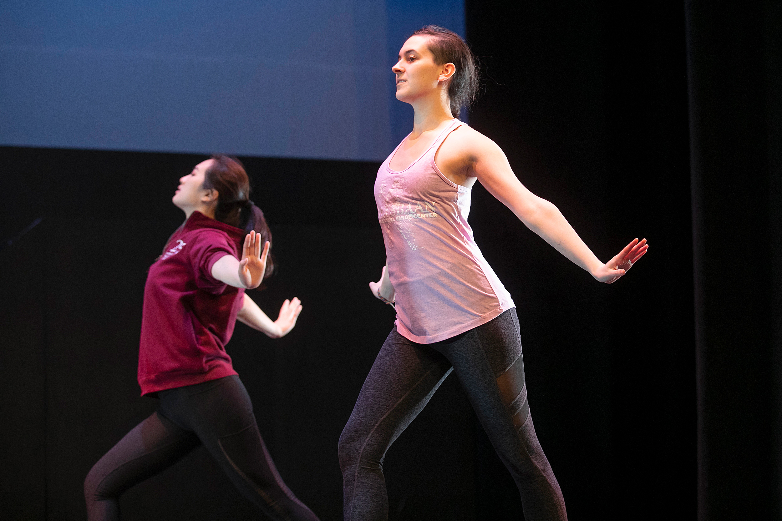 Dancers arch forward with arms stretching back.