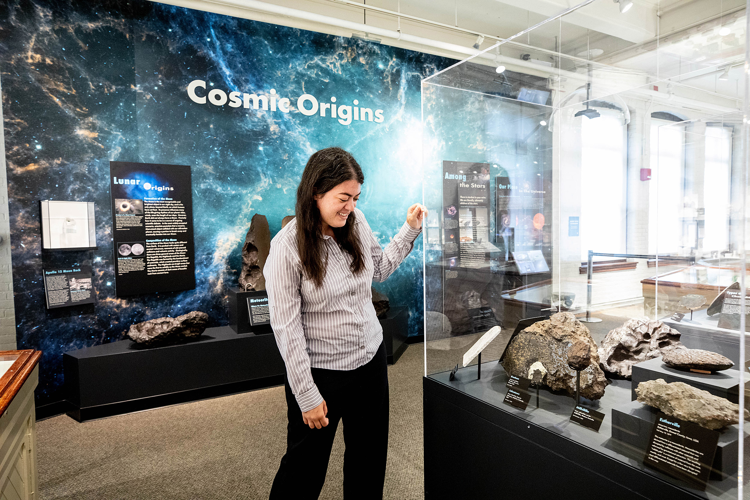 Woman looking at space rocks in a display case