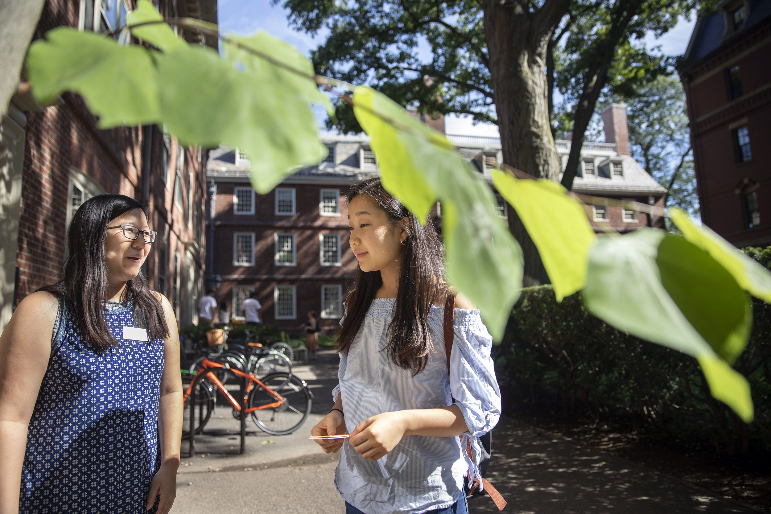 A proctor greets a students outside Straus Hall