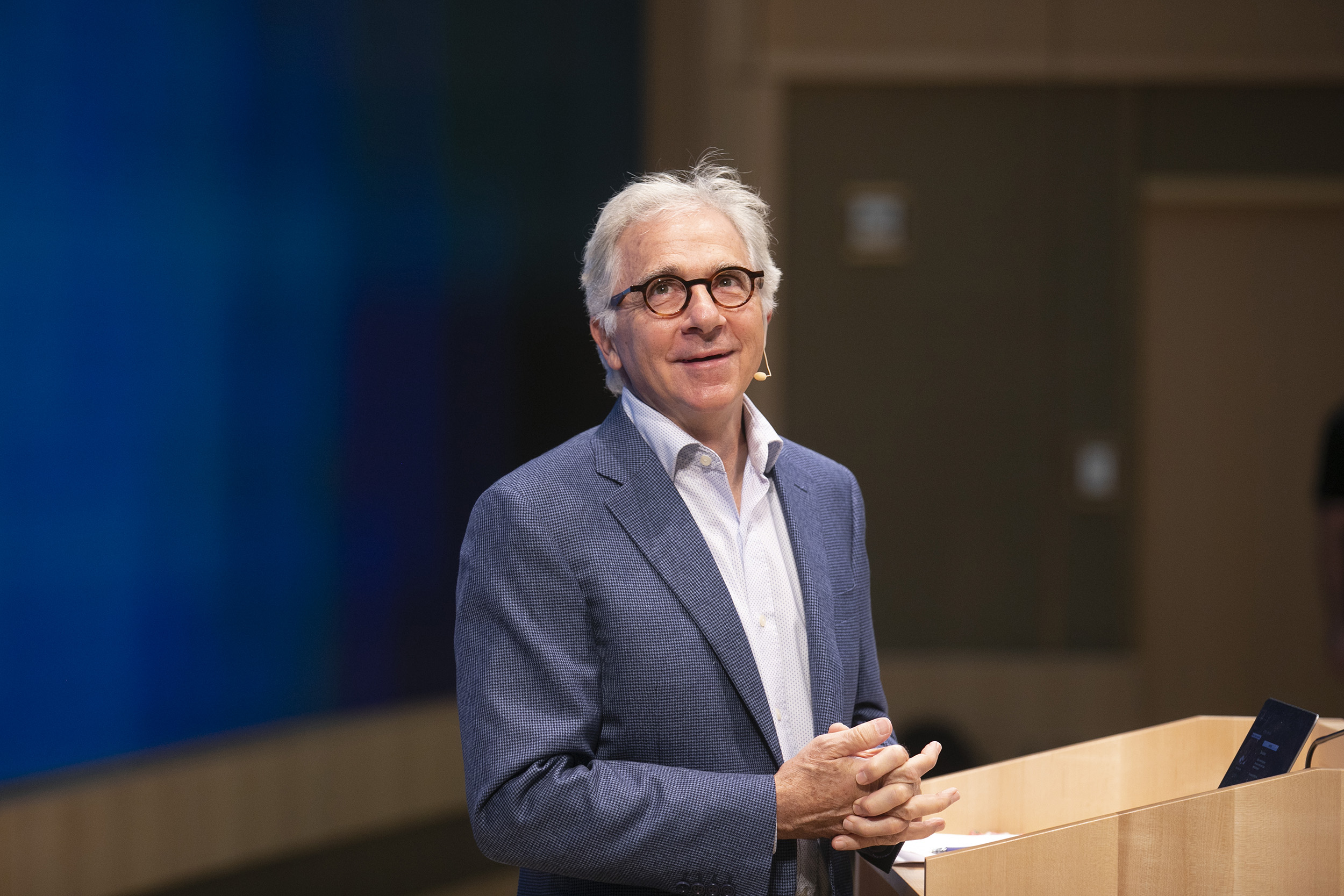 Douglas Melton speaks from podium during class.