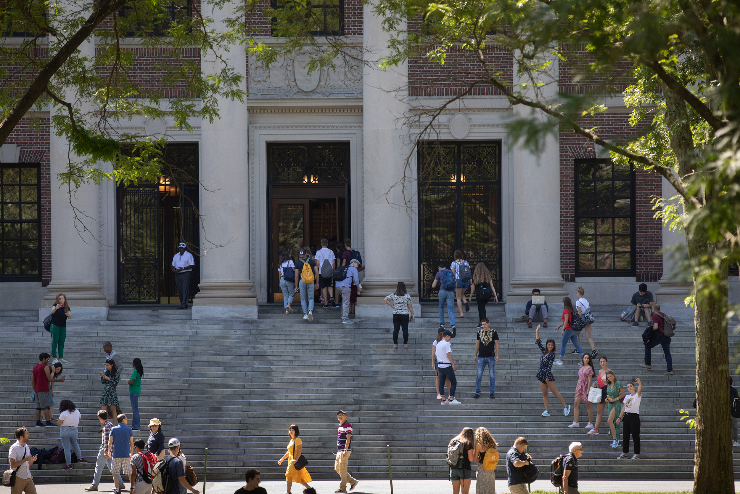 As students return to campus they gather outside Widener Library