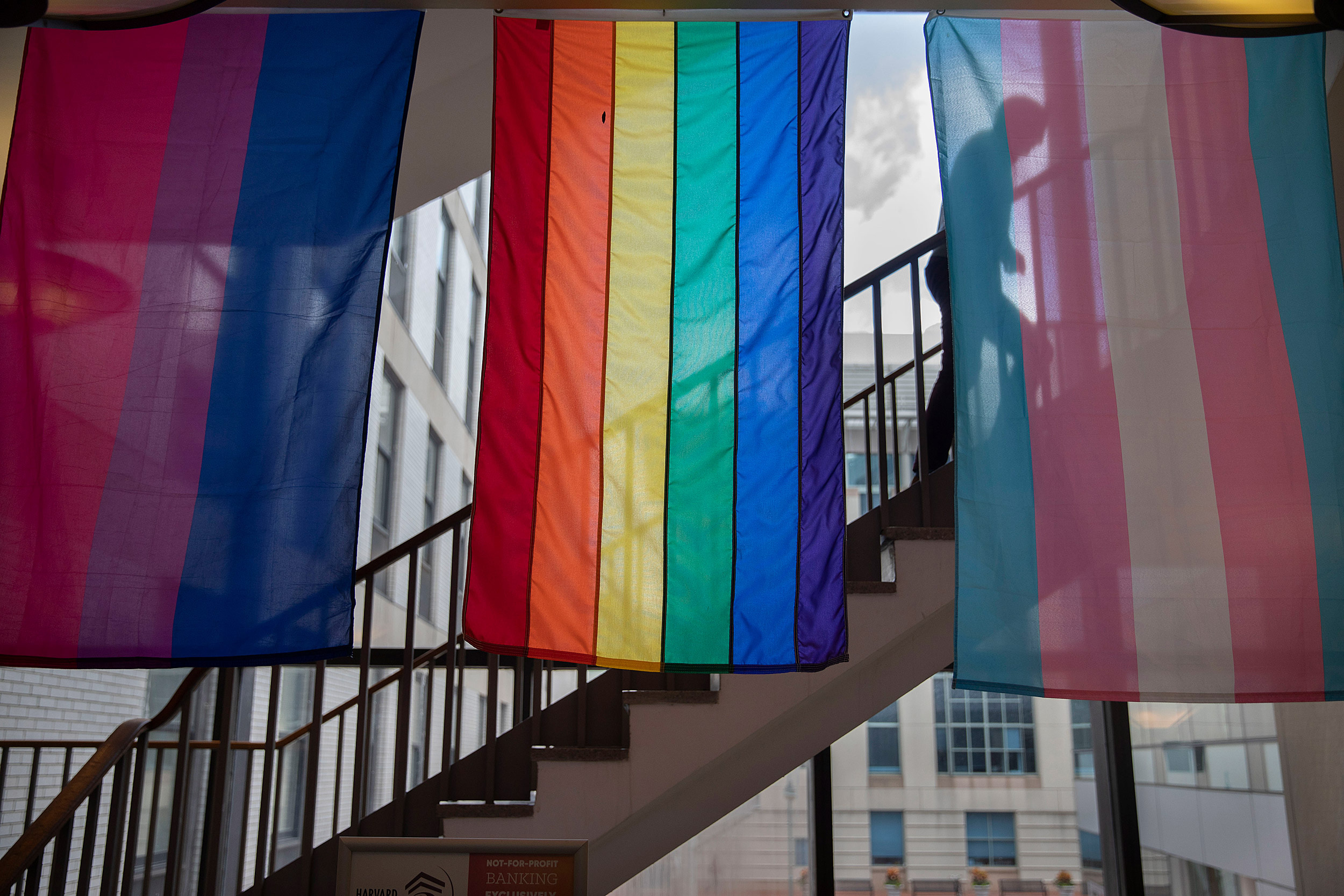 Student walking up stairway with colorful flags hanging from ceiling.