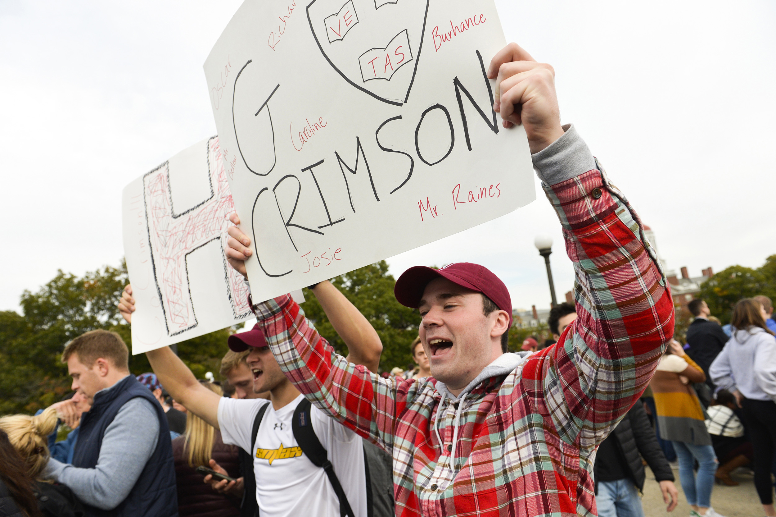 First-years Alex Baker and Brendan Kiely shout their support as the Harvard heavyweight eight pass beneath the Weeks Footbridge.