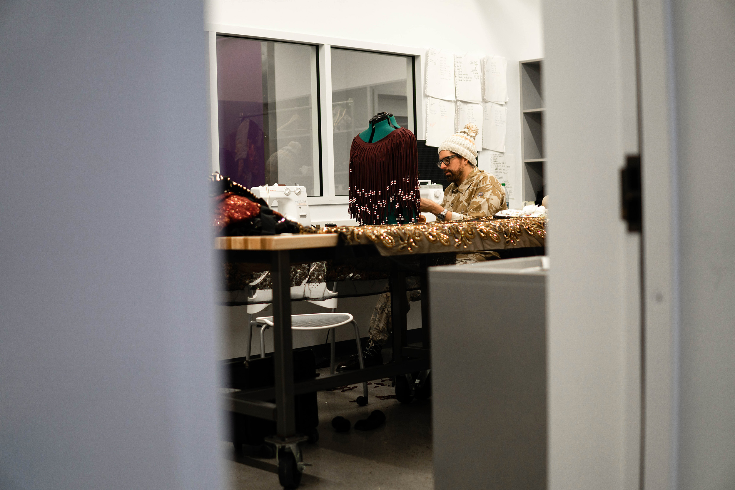 Visiting artist Machine Dazzle works on costumes.