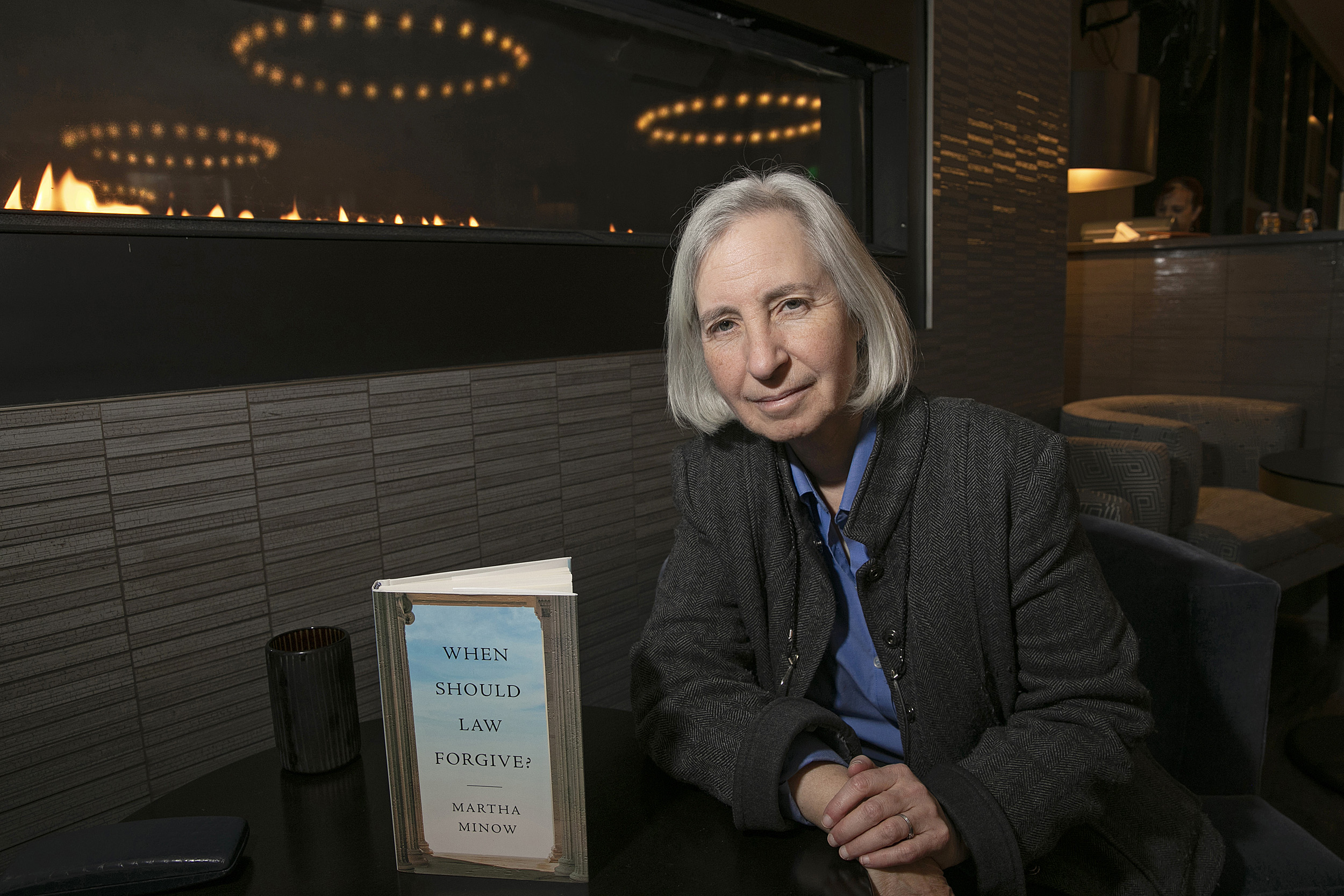 Professor Martha Minnow sitting at a table with her book in front of her.