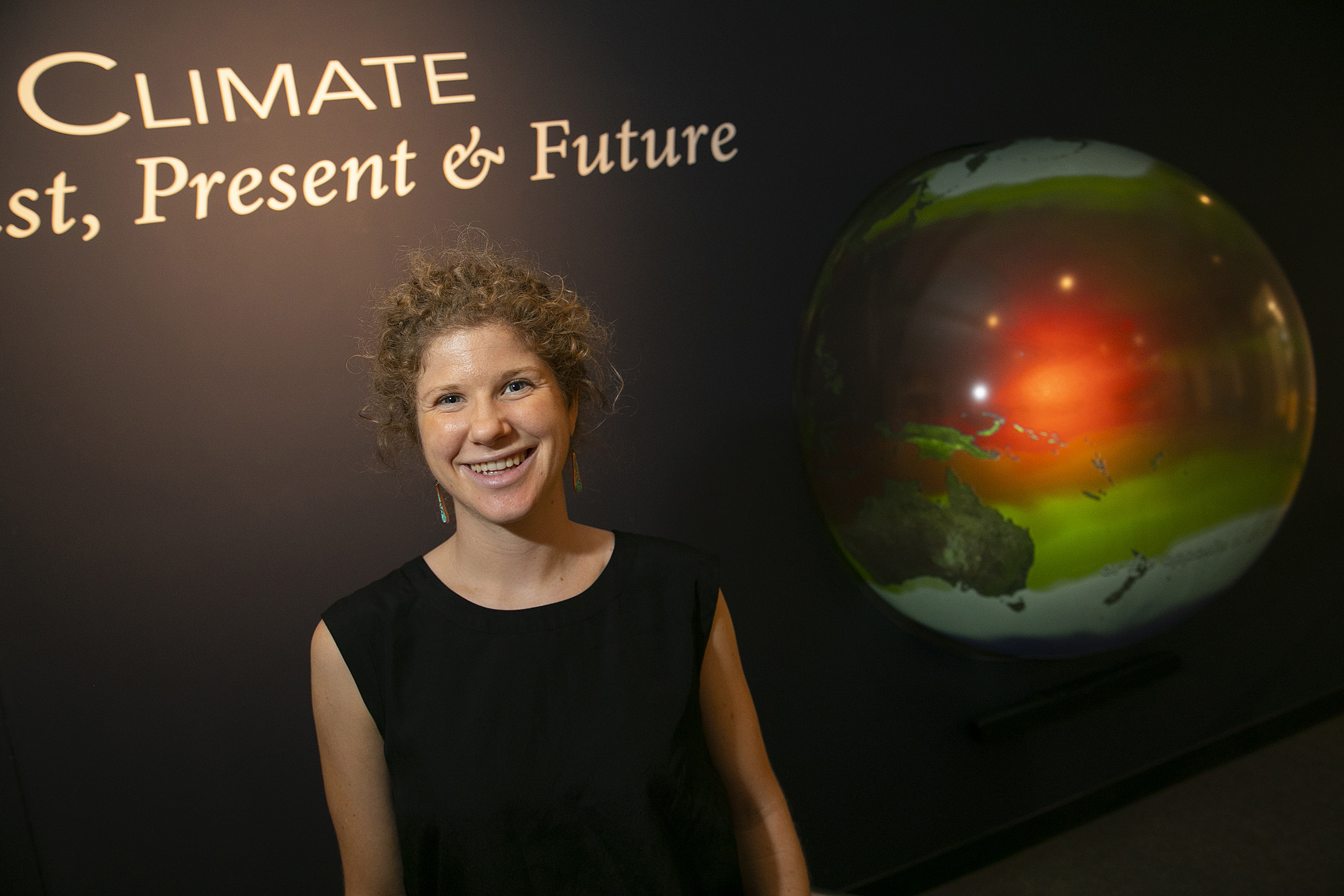 Tamara Pico in front of an image of the Earth.