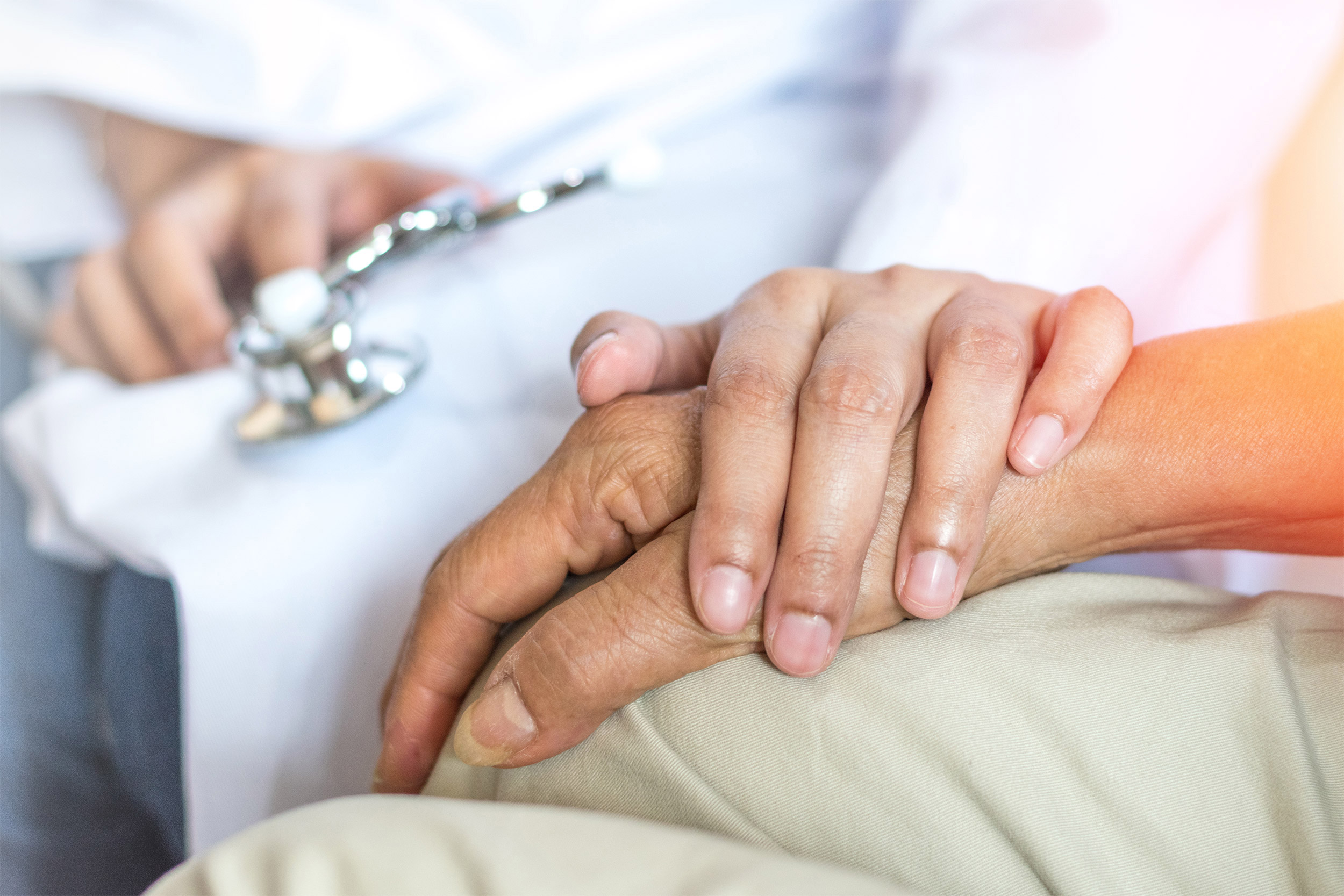 Doctor holding hand of patient.