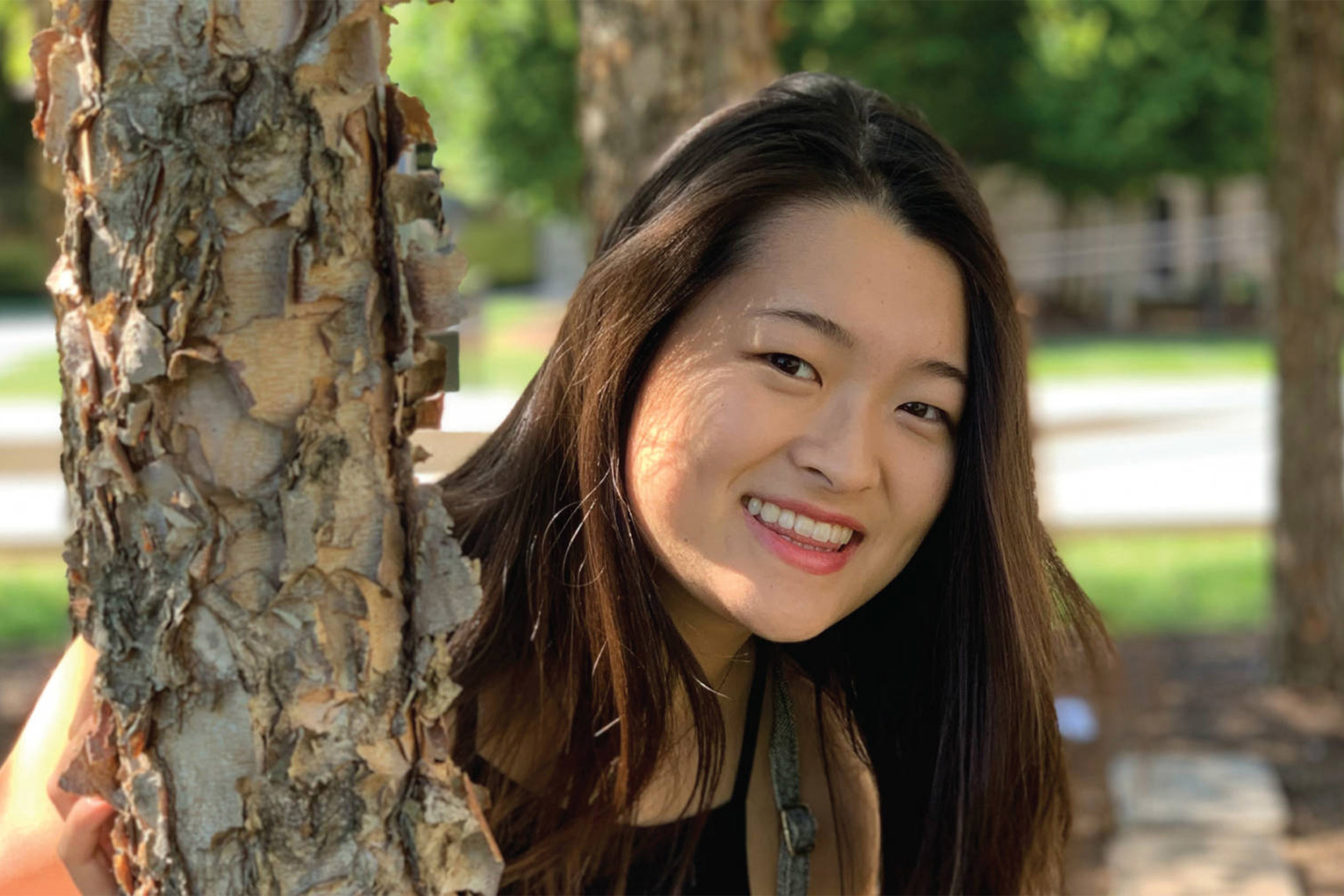 Julia Riew standing by tree.