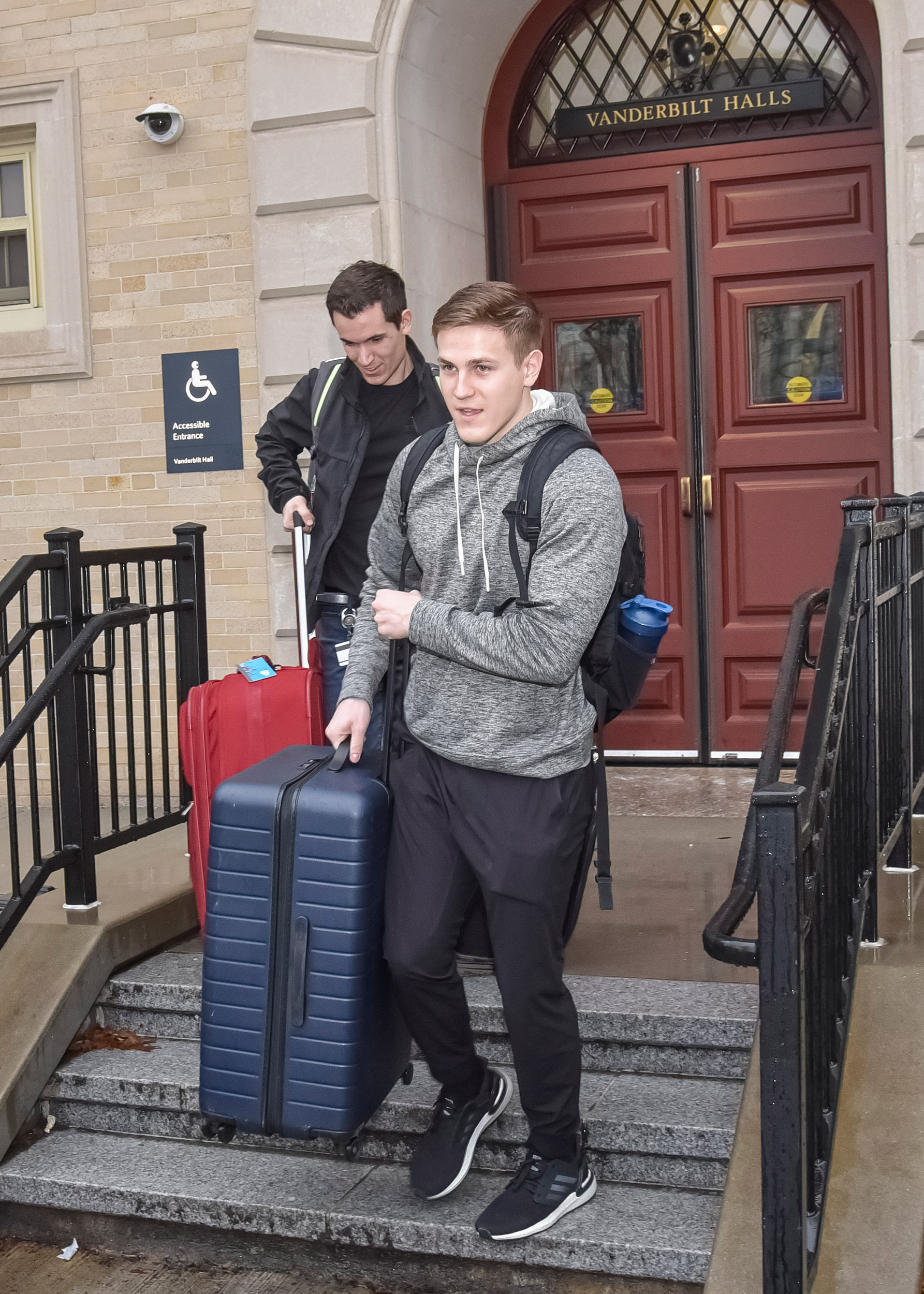 Two students with suitcases.