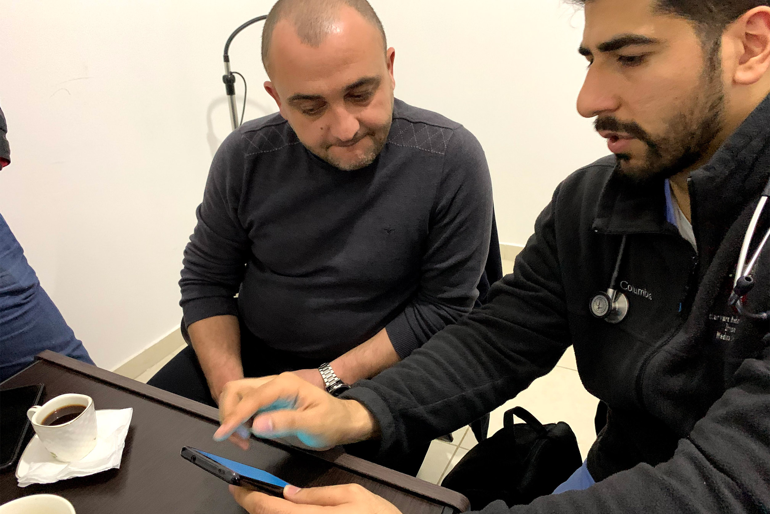 Senan showing Endless Medical Advantage physician Dr. Feras Alghadban Hikma Health's app.