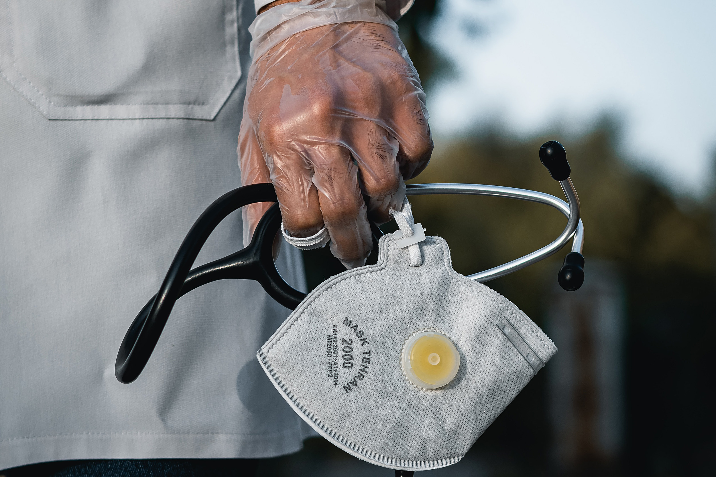 Person holding stethoscope and mask.