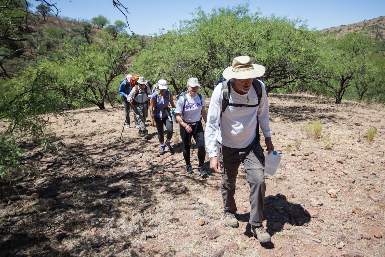 Five people walking in the dessert