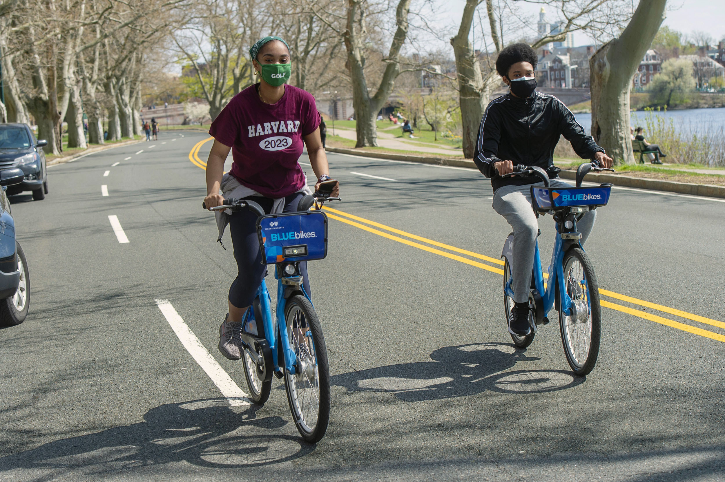 Daniela Diaz ’23, left, and classmate Kilando Chambers ’23 bike along the closed roadway on Memorial Drive.