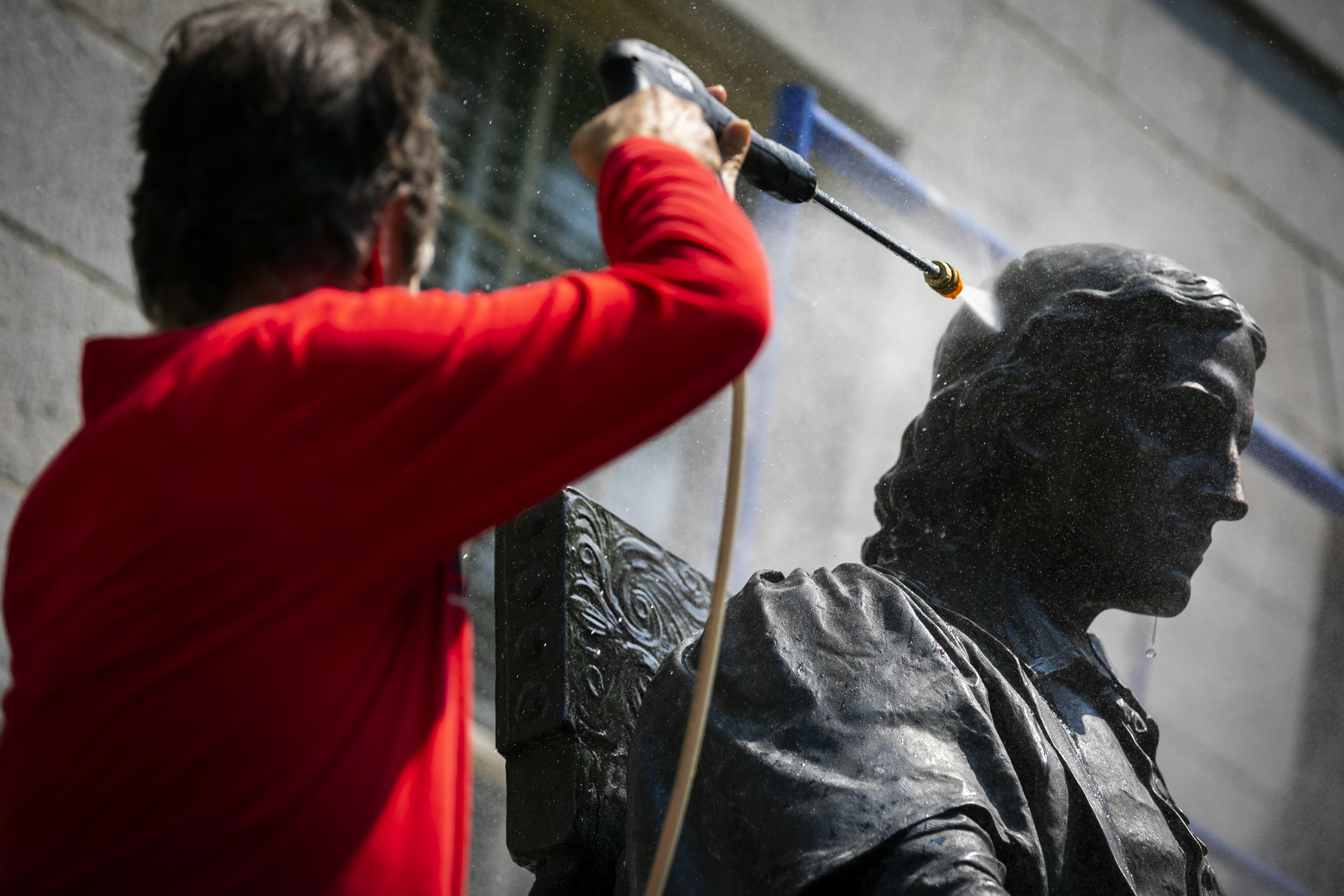 John Harvard statue being cleaned.