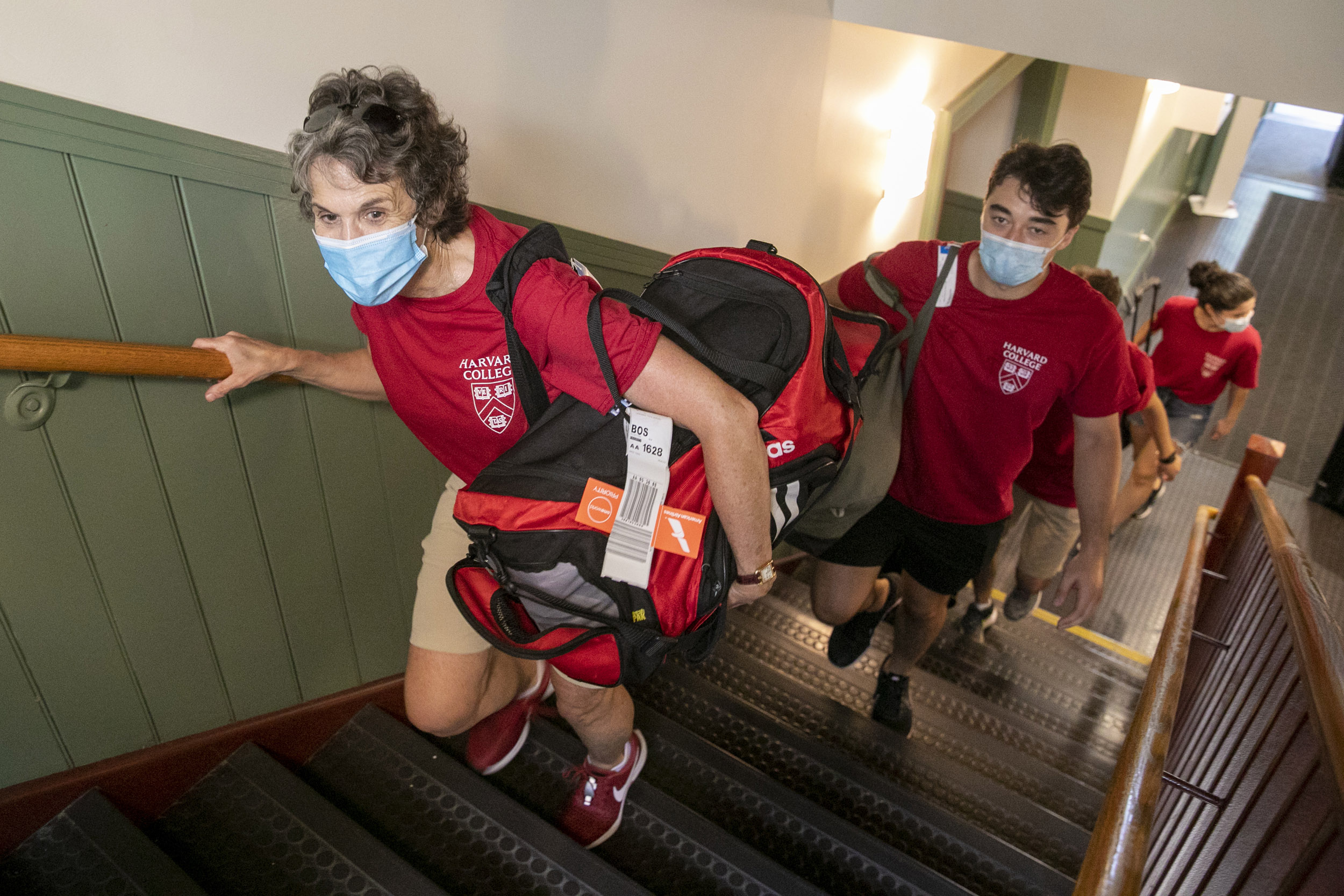 Adele Bacow carrying a bag upstairs.