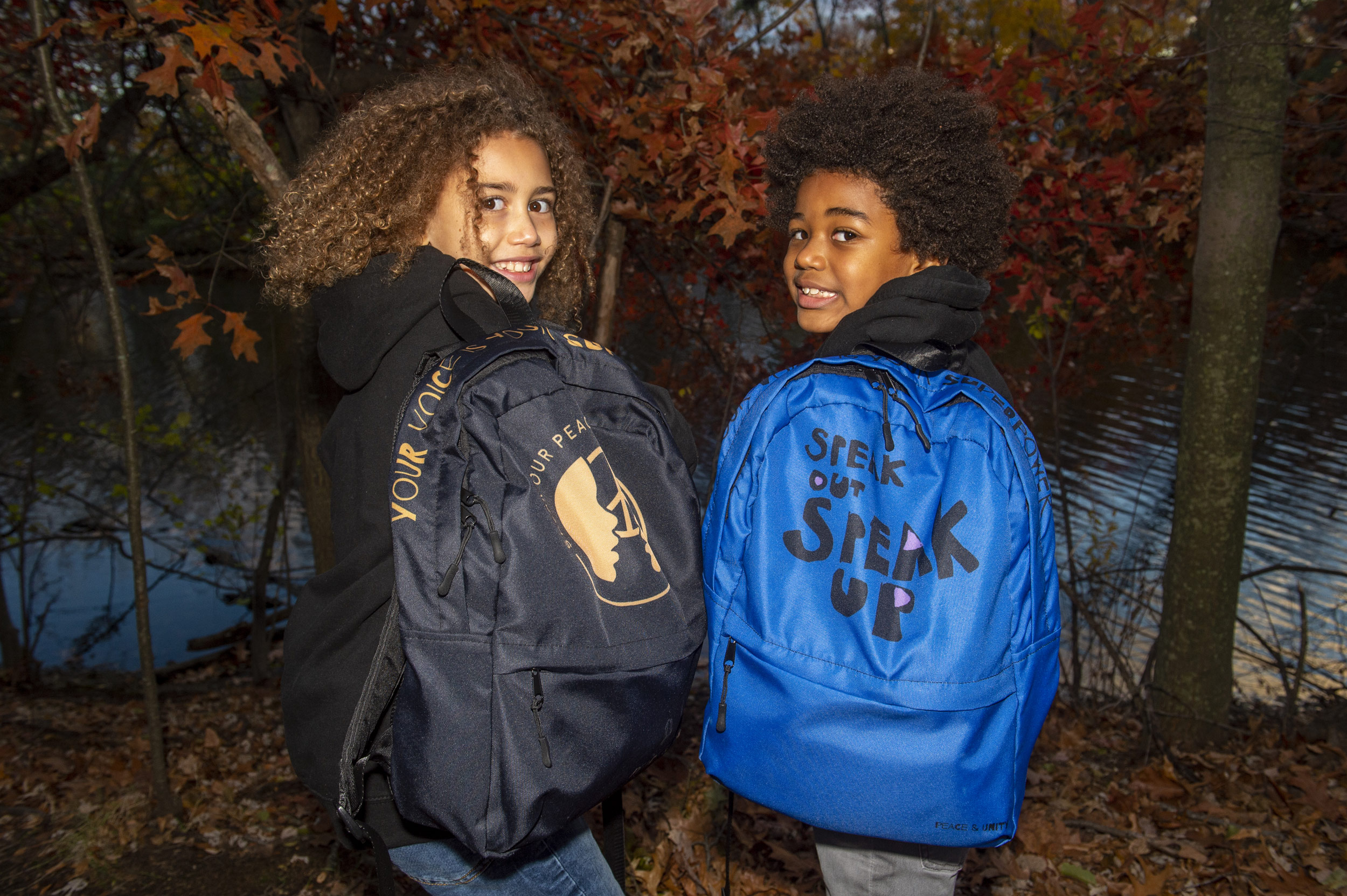 Children displaying backpacks they designed.