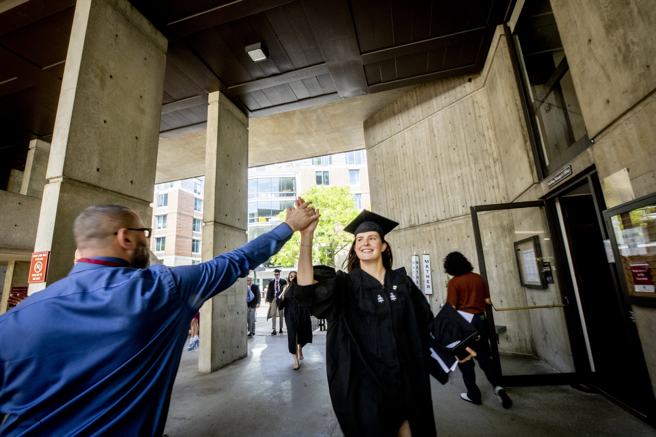 Mather House Manager Miguel Casillas high fives Emma Buckles.