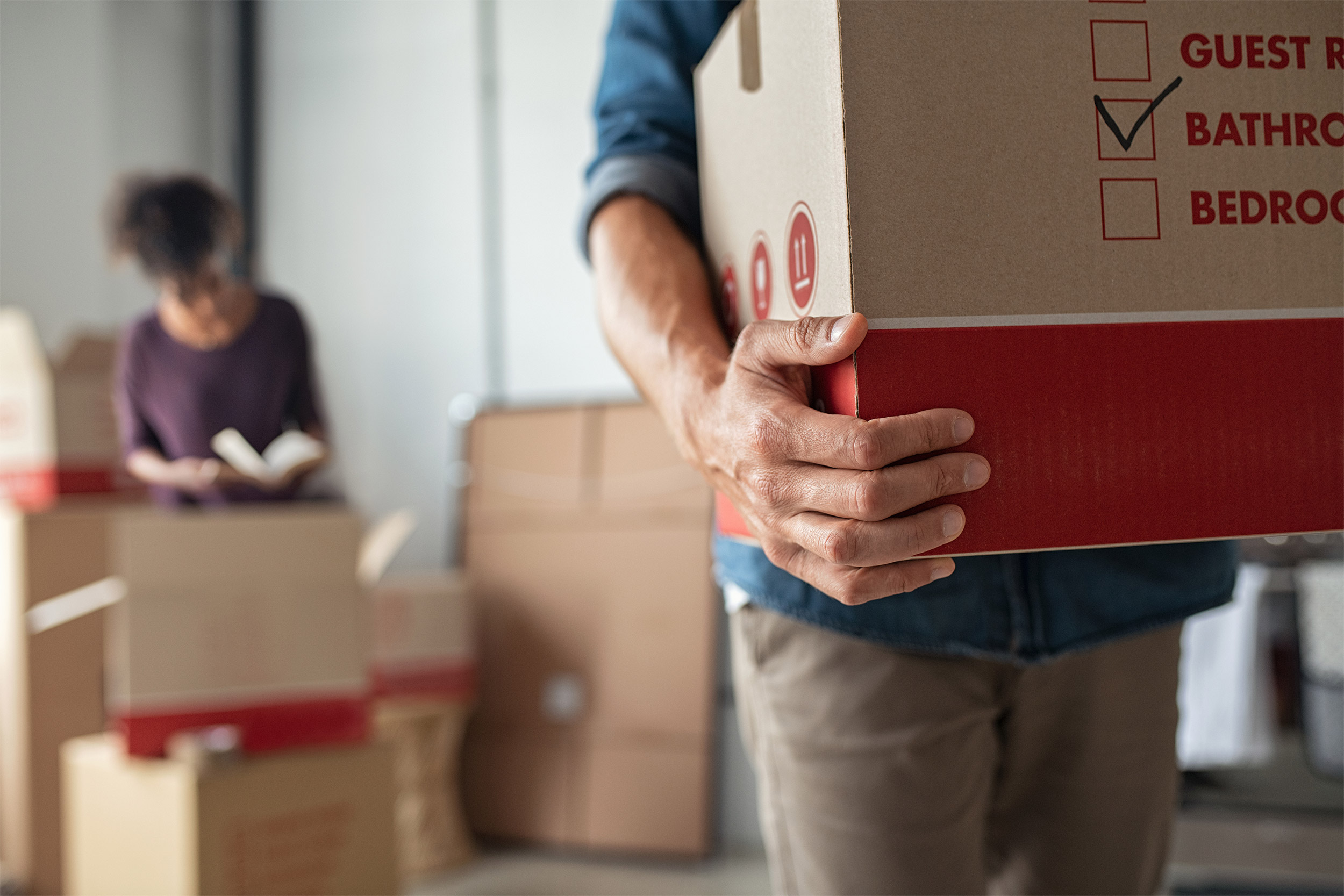 Young couple moving with boxes in hand.