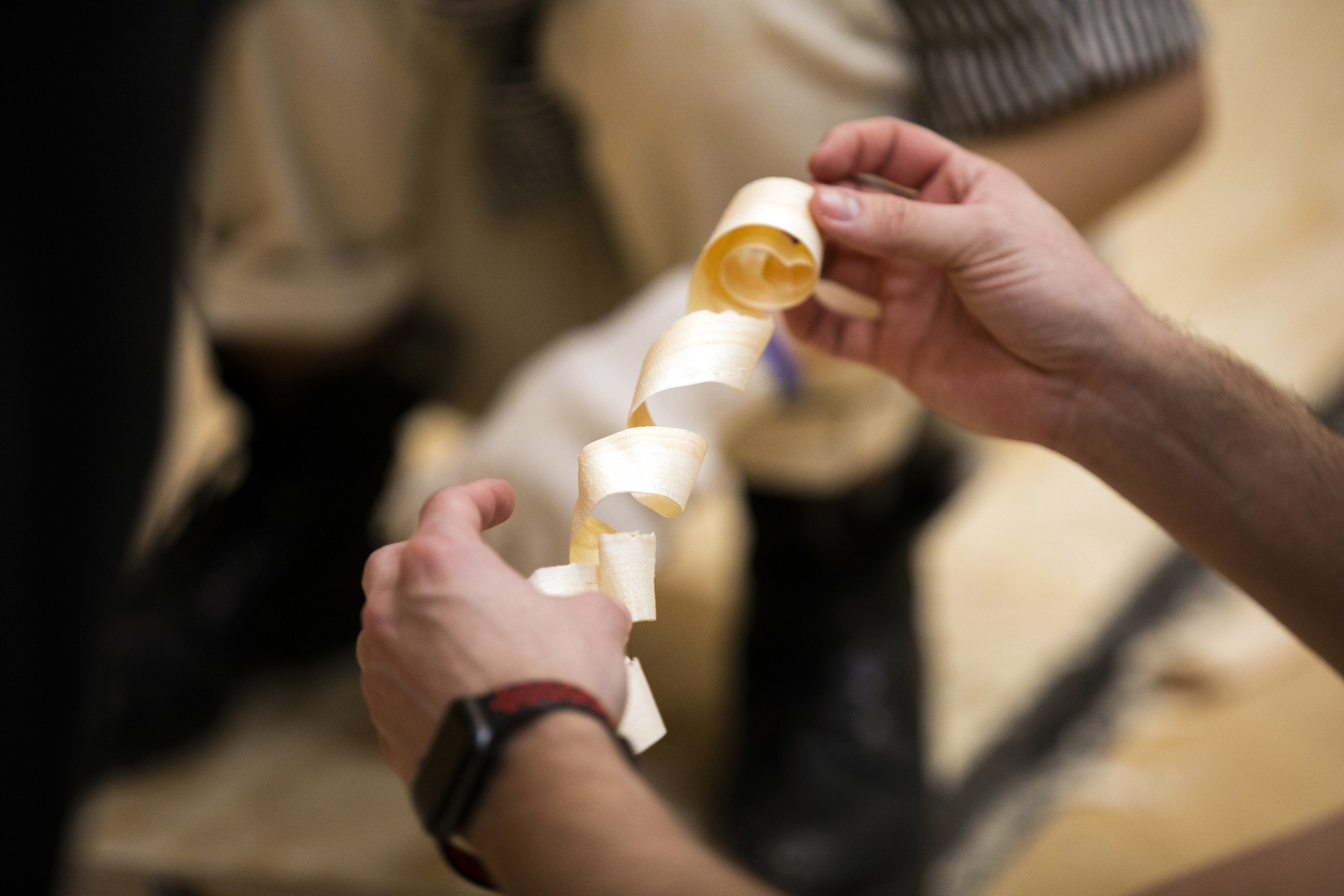 A student admires a wood shaving.