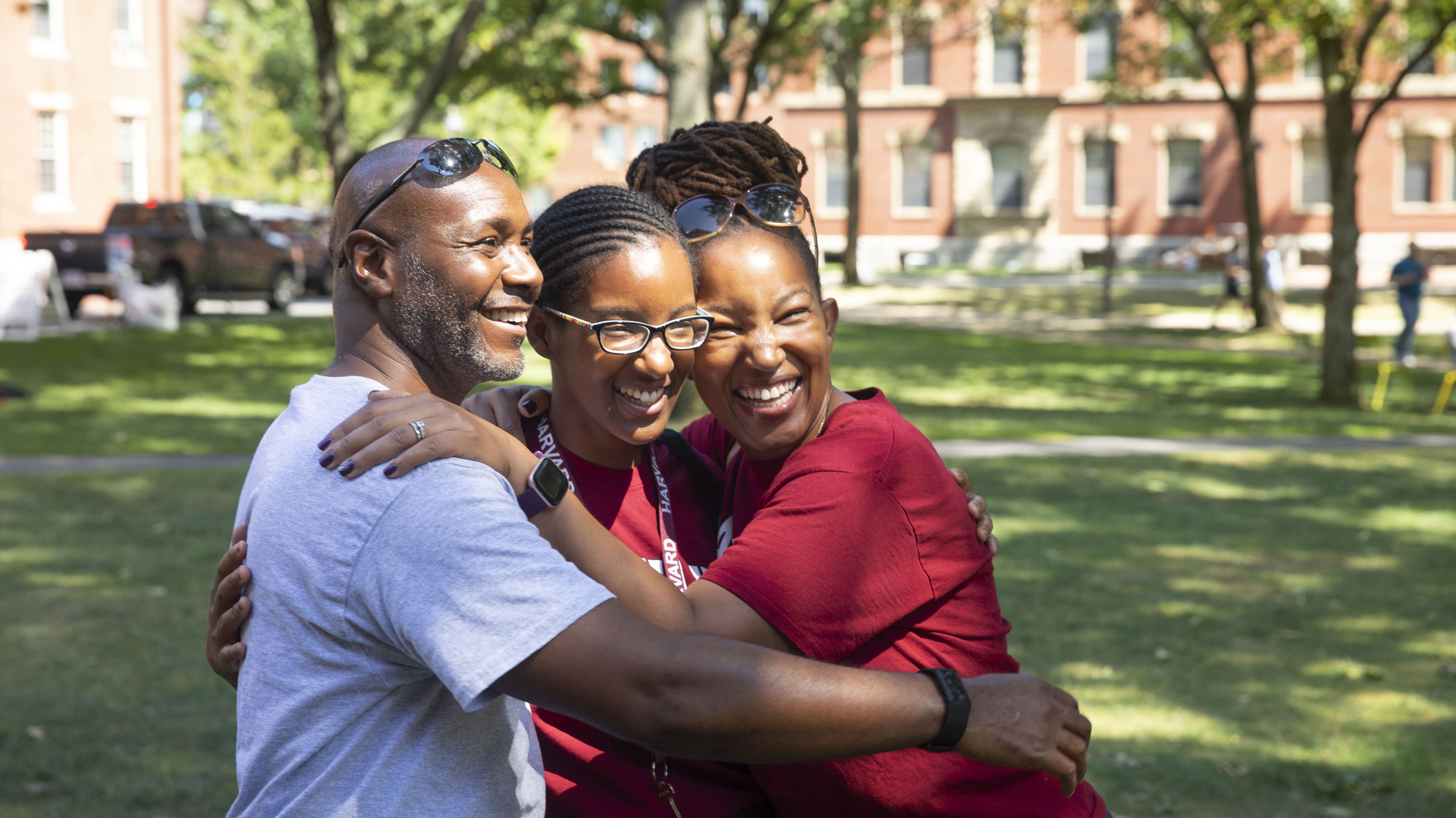 Lulu August ’26 (center) is hugged by her proud parents, Kakuri and Agnes.