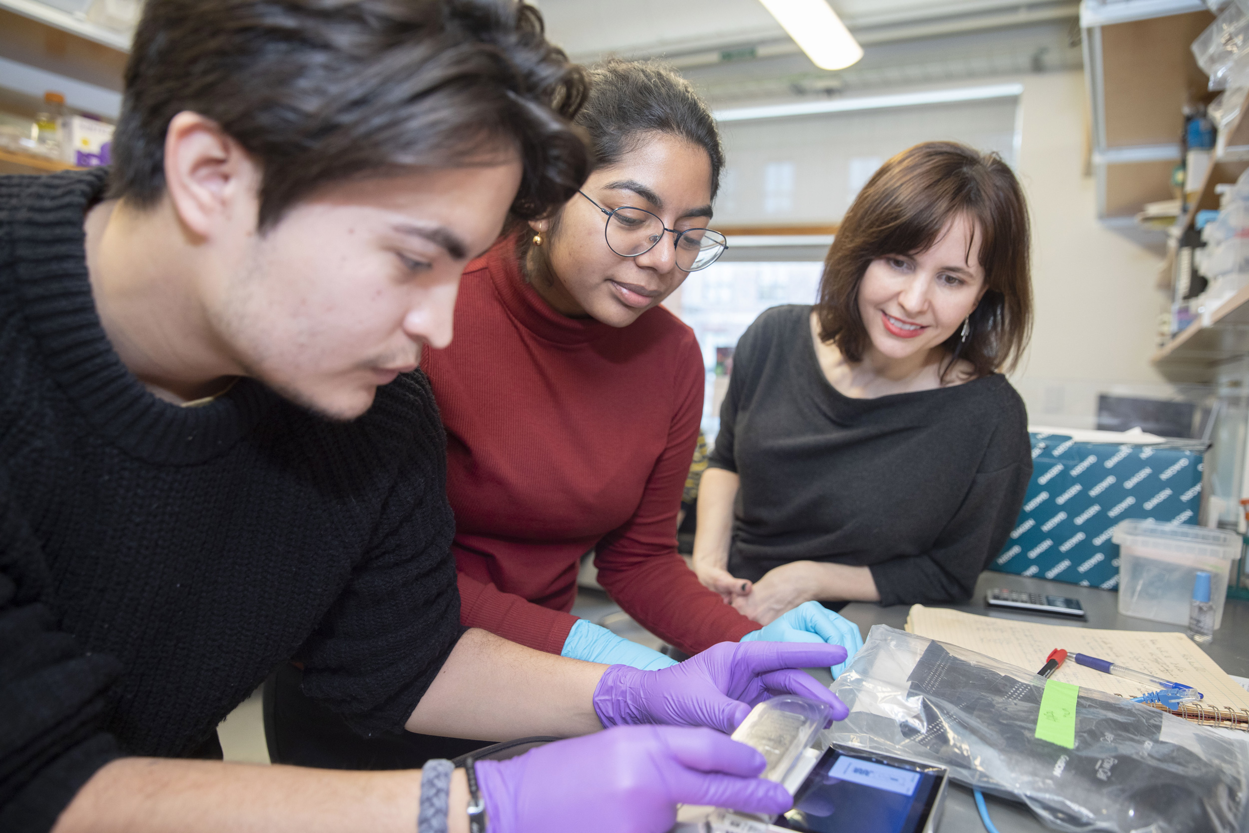 Noah Lopez, Shifa Hossain ’23, and Jessica Whited engage in research using a MinION bench top.