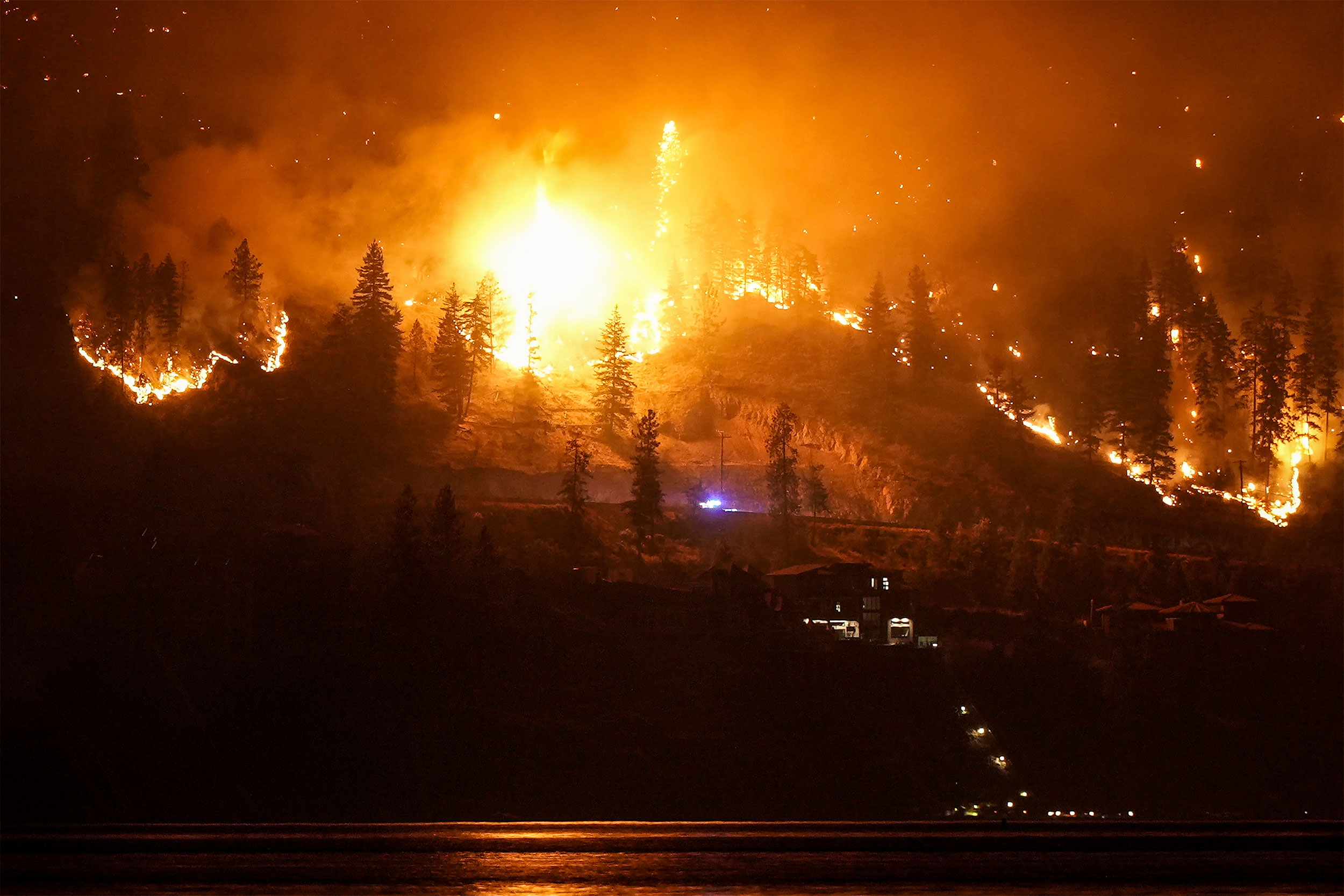 A wildfire burns on the mountainside in West Kelowna, Canada.