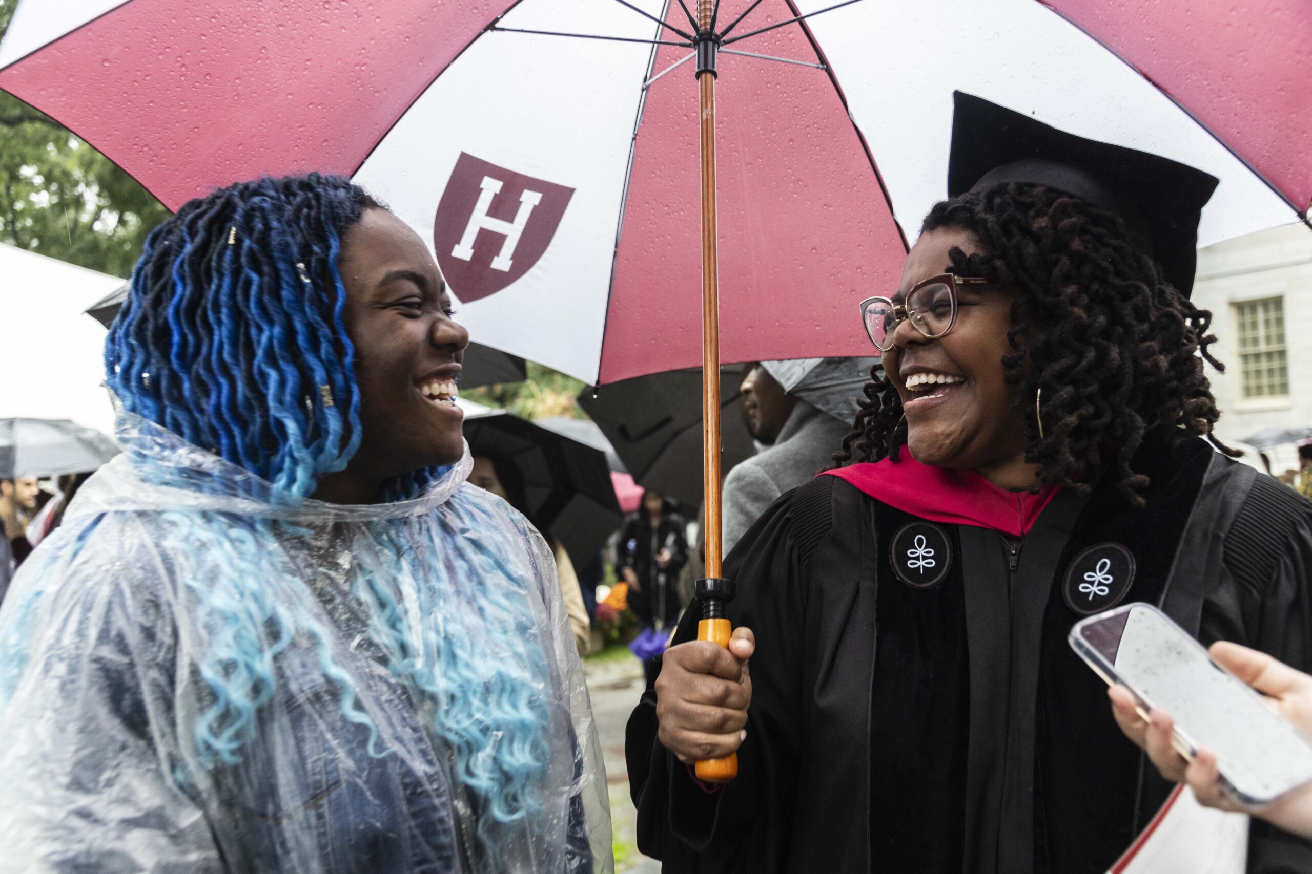 Leticia Sefia and Ebonee Green laughing under umbrella.