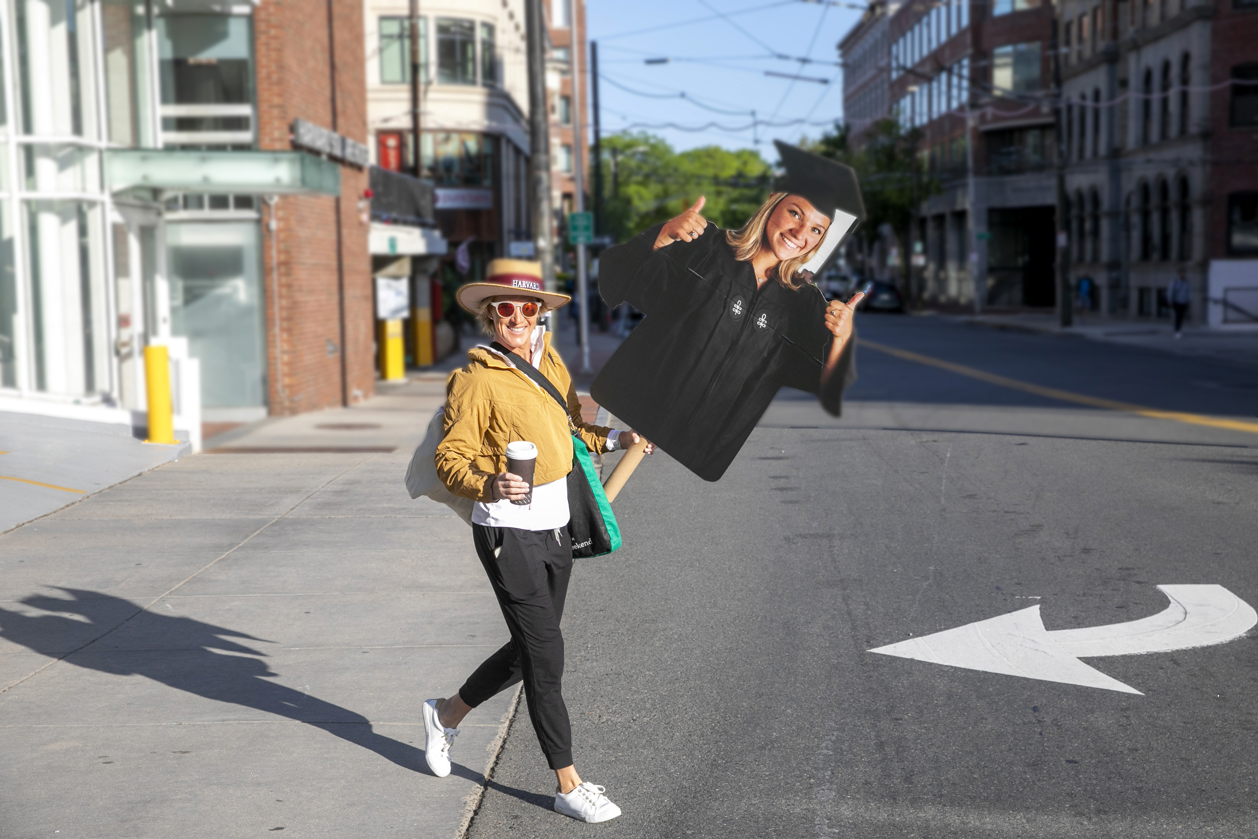 Kelly Jenkins carries a large photo of her daughter Shea as she heads to commencement.