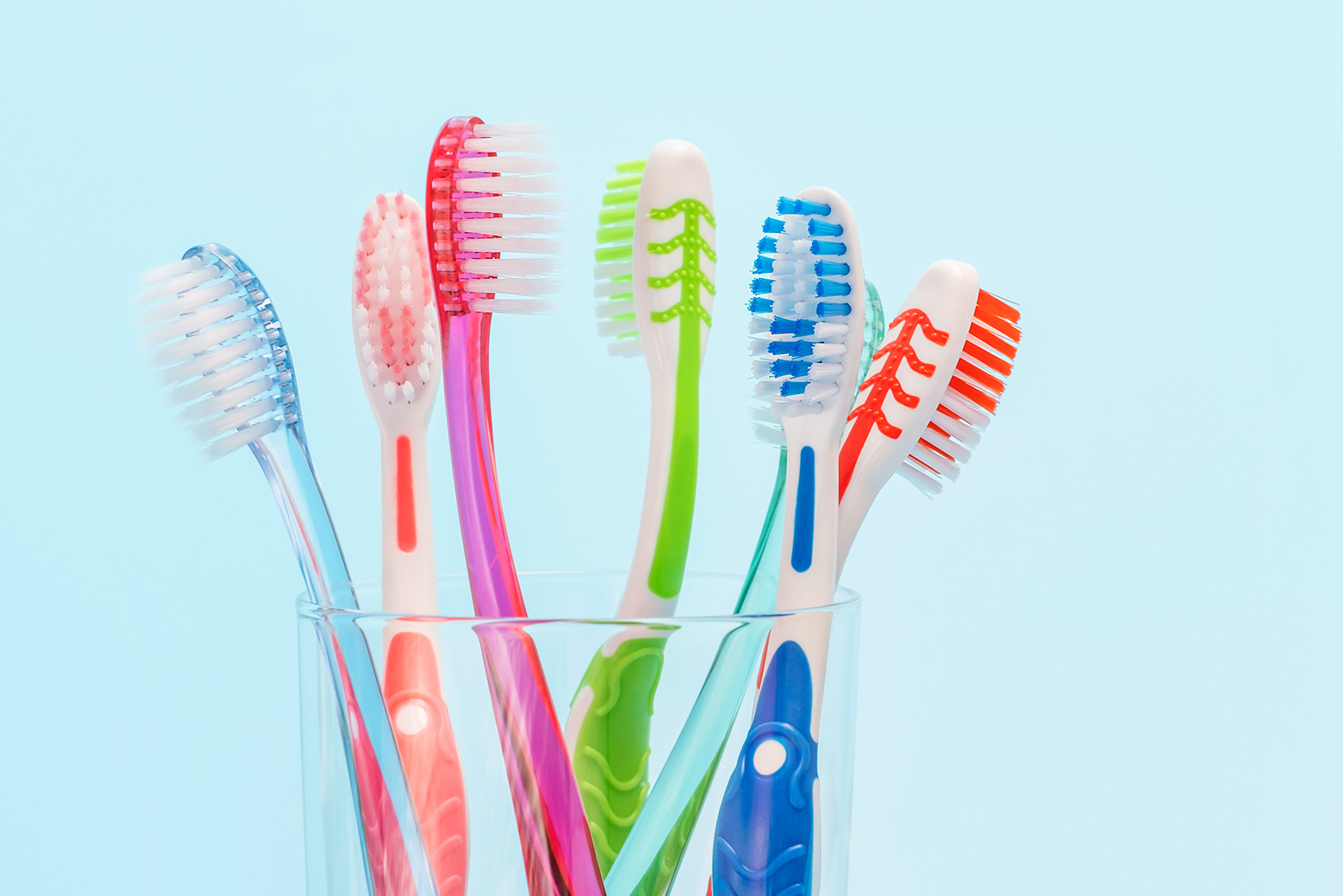 Glass filled with toothbrushes.