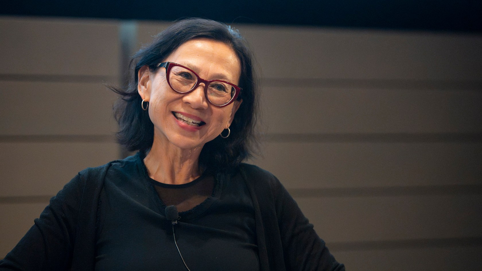 Yu-Wen Wu wearing glasses and gold hoop earrings as she smiles. 