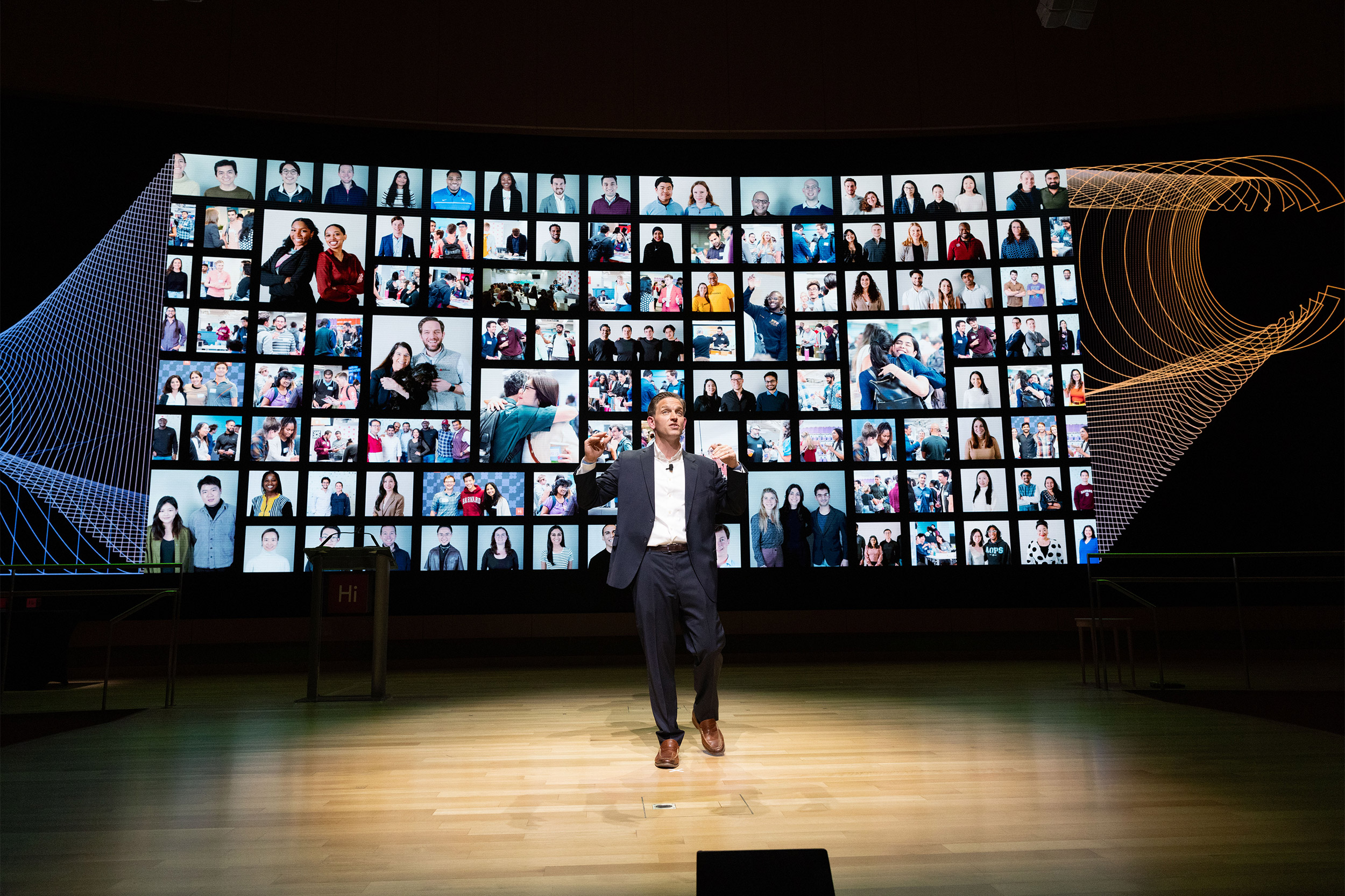 Matt Segneri, the Bruce and Bridgitt Executive Director of the Harvard Innovation Labs, stands in front of a screen filled with members of the i-lab community.

