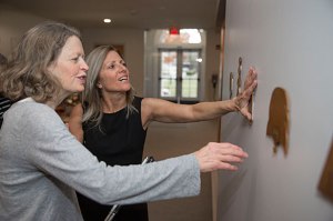 Artist Wendy Jacob (grey shirt) has created an installation with the blind and hearing impaired in mind. She tours the exhibit with writer, Nina Livingstone, (black dress) who is blind and hearing impaired. The exhibit features vibrating walls and architectural models from schools for the blind and is housed at the Johnson-Kulukundis Family Gallery in Byerly Hall. Kris Snibbe/Harvard Staff Photographer