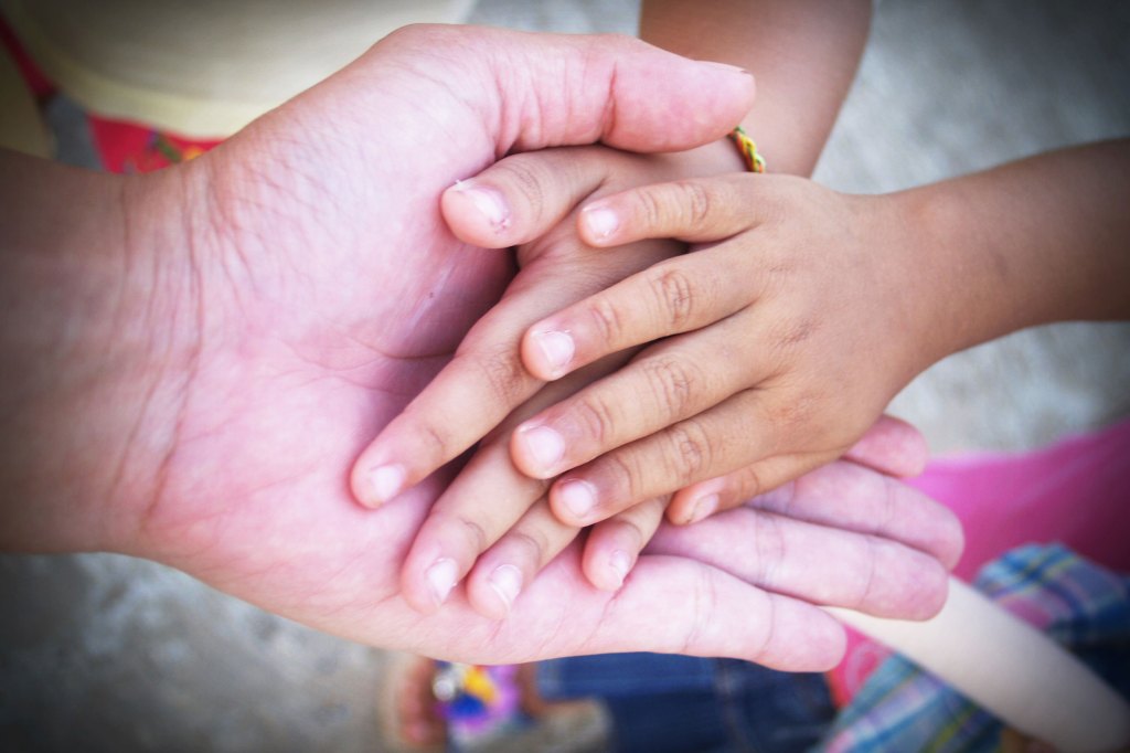 Elderly hand holding child's