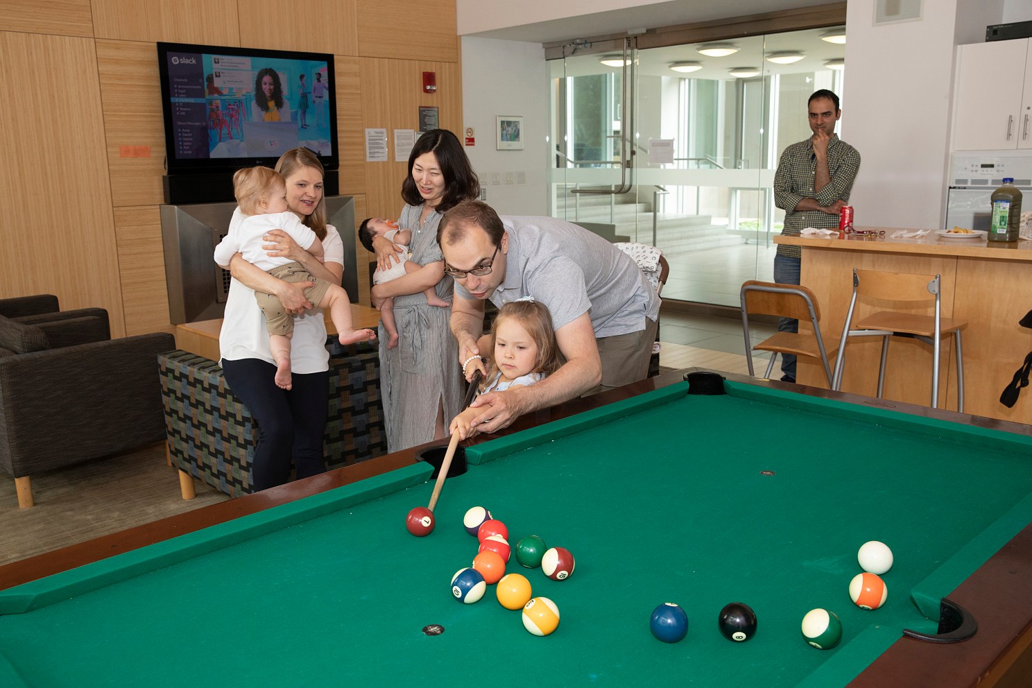 family playing pool at grad commons