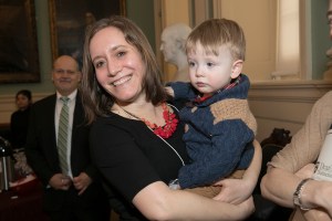 A woman holds her toddler.